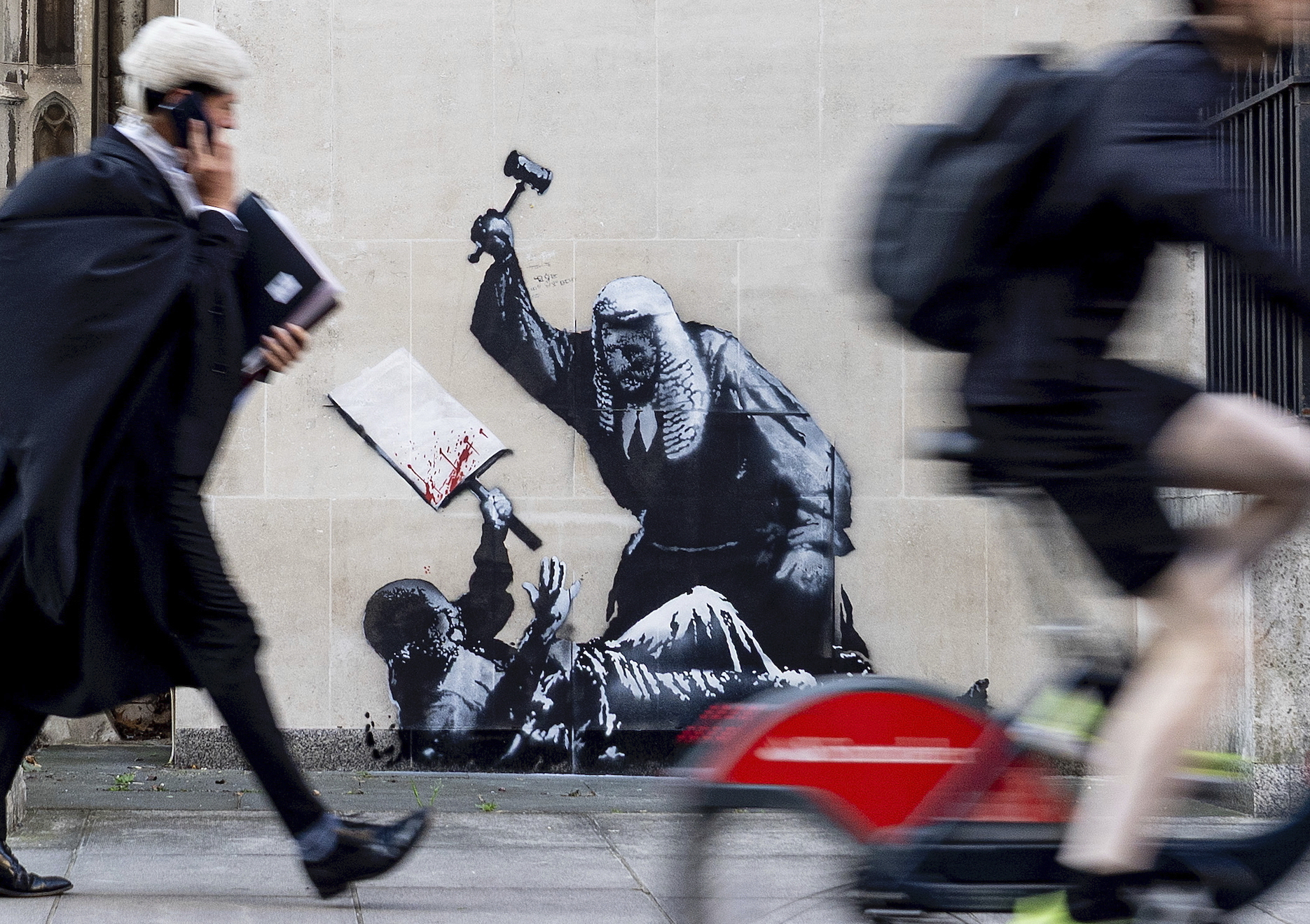 Undated photo released by Banksy of the new artwork by the artist which portrays a judge beating a protester with a gavel at the Royal Courts of Justice in London. (Banksy via AP)