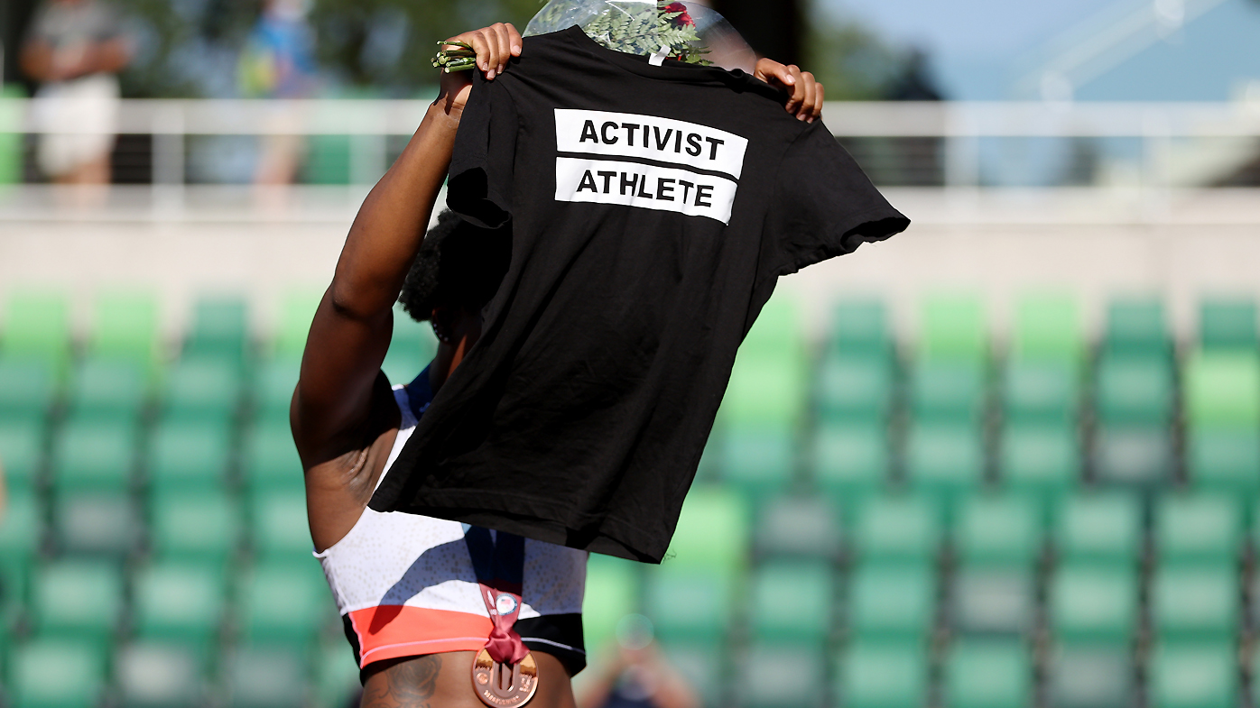 Gwendolyn Berry displays an Activist Athlete shirt as she celebrates finishing third