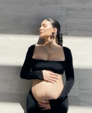 Kylie Jenner displays baby bump in pregnancy video.