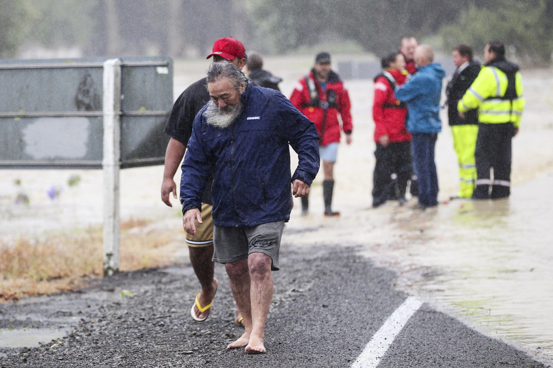 People move away from flood water in Hastings, southeast of Auckland, New Zealand, Tuesday, Feb. 14, 2023.