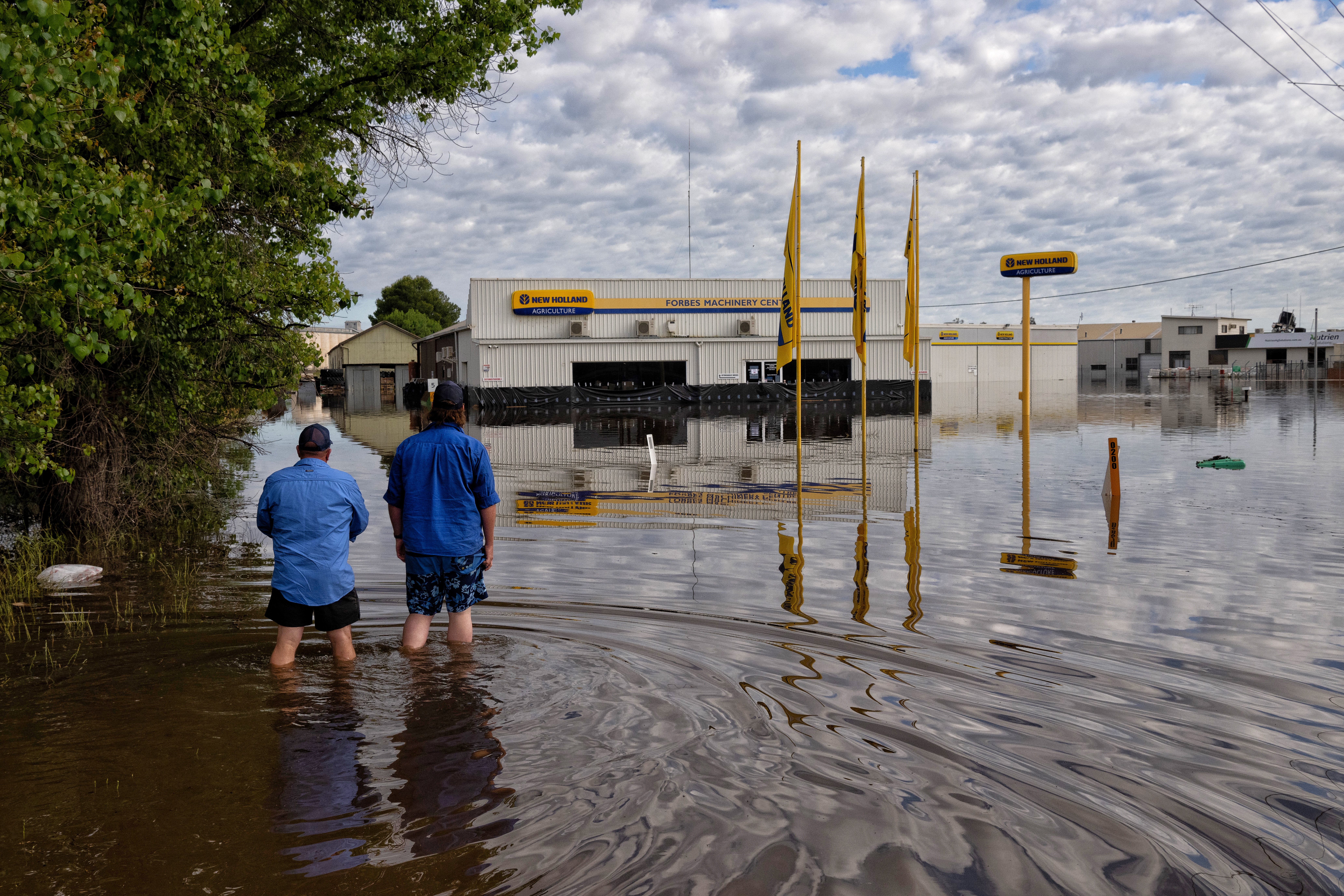 Workers inspect flooded businesses on the Newell Hwy on the northern part of Forbes.