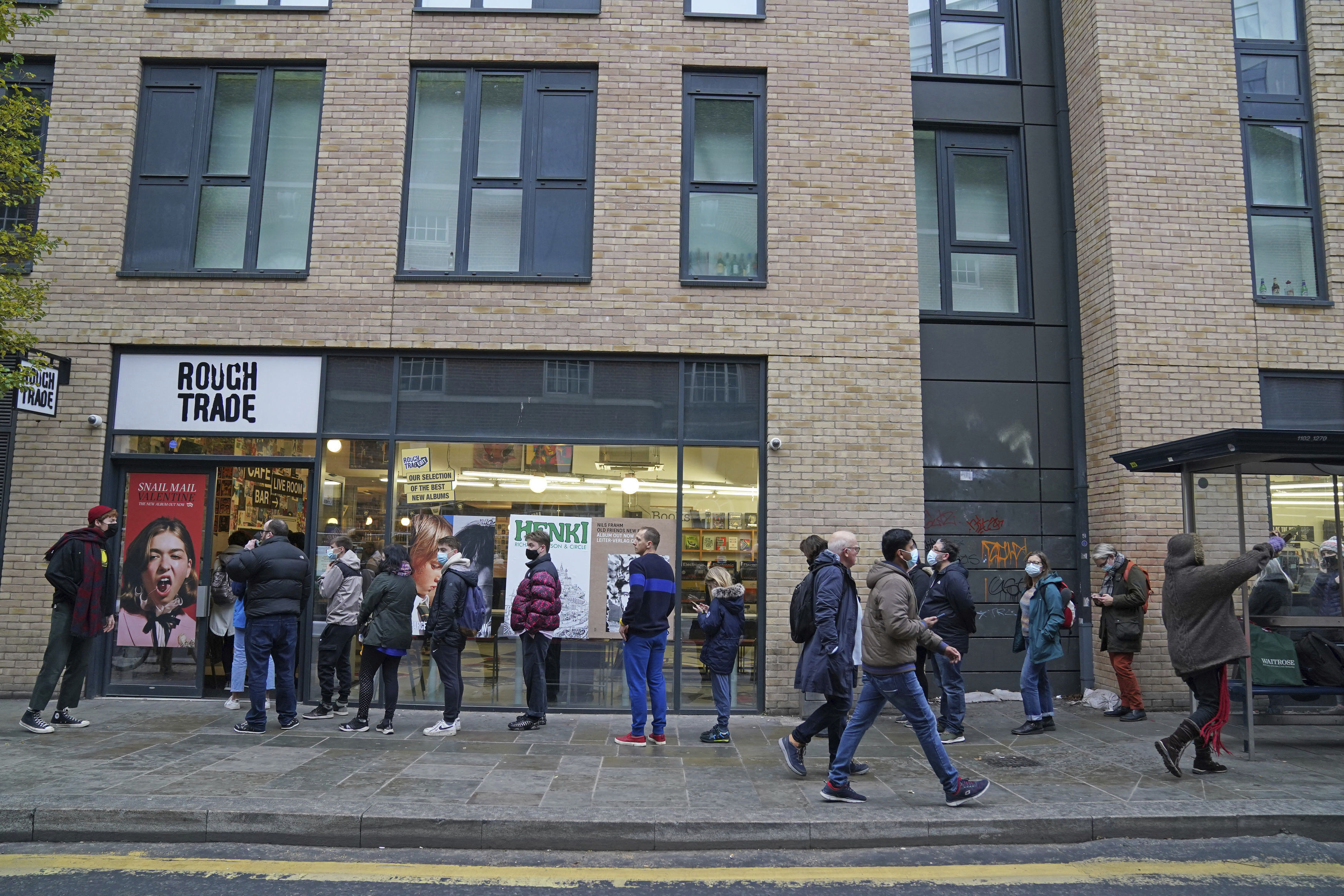 People queue outside Rough Trade in Bristol, England, Saturday Dec. 11, 2021, where a T-shirt designed by street artist Banksy is being sold to support four people facing trial accused of criminal damage in relation to the toppling of a statue of slave trader Edward Colston