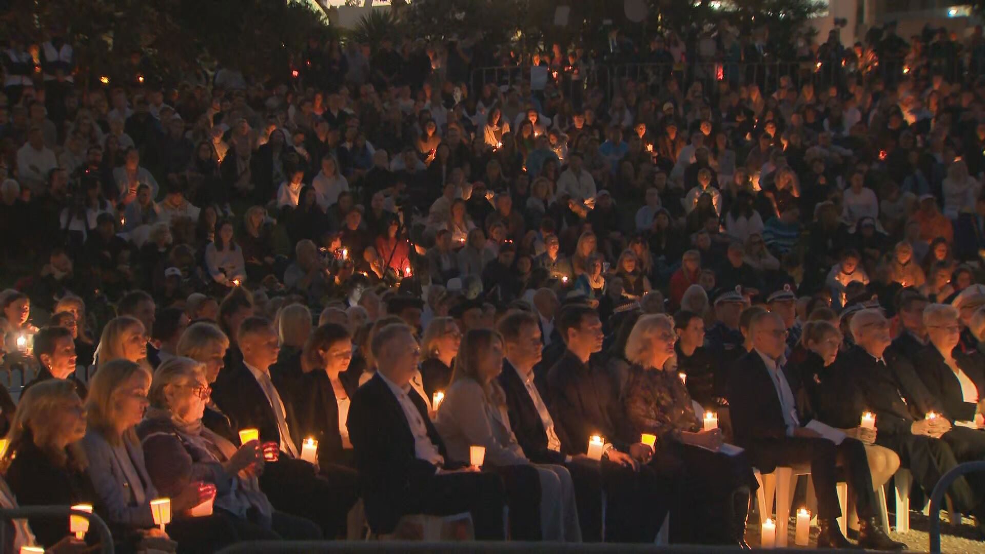 Bondi Beach has fallen silent this evening as thousands gathered for a candlelight vigil.