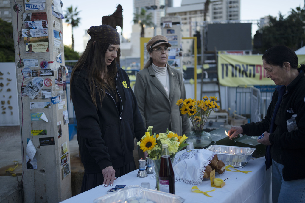 Familiares y partidarios de rehenes retenidos por el grupo militante Hamas en la Franja de Gaza marcan el inicio del Shabat en Tel Aviv, Israel, el viernes 24 de enero de 2025. (Foto AP/Maya Alleruzzo)