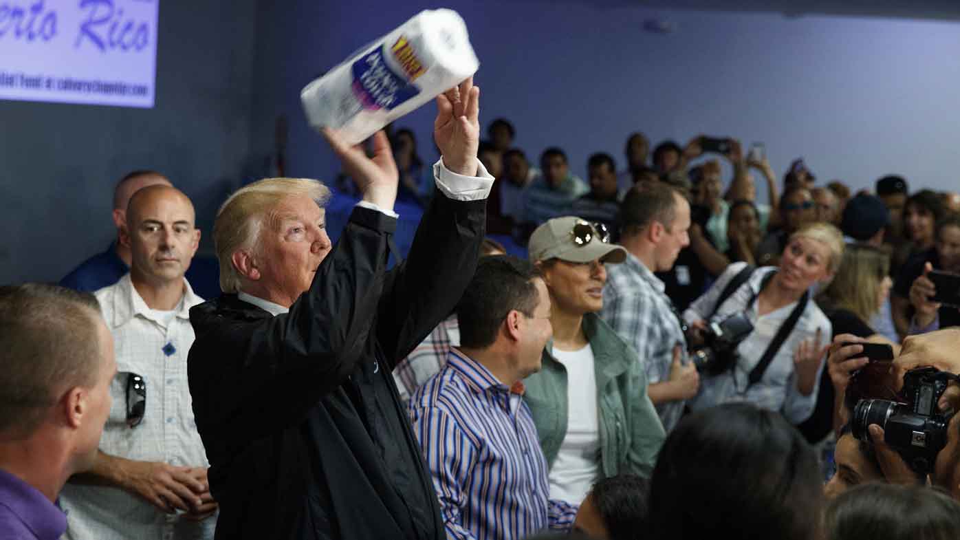 El presidente Donald Trump arroja toallas de papel a la multitud durante su visita a Puerto Rico tras el huracán María.