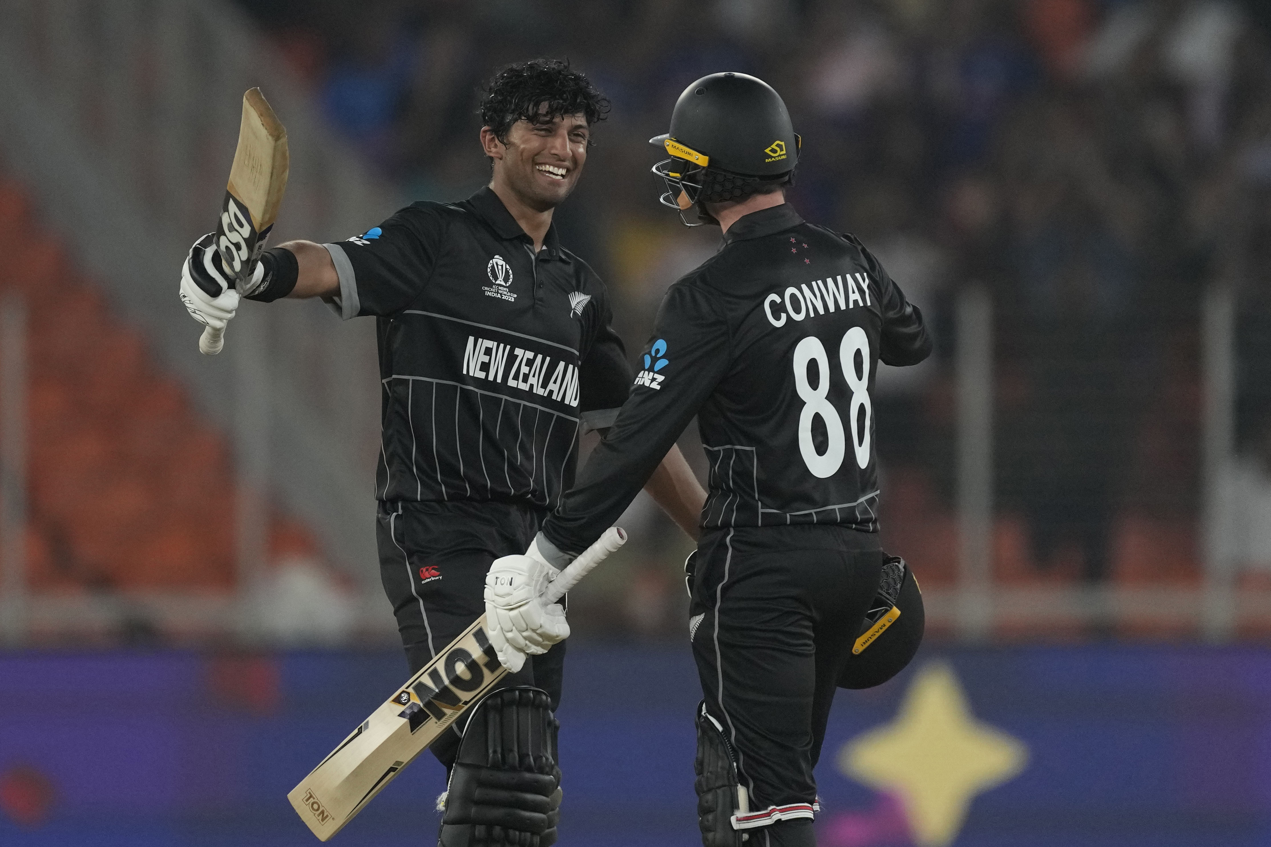 New Zealand's Rachin Ravindra celebrates his century with teammate Devon Conway.