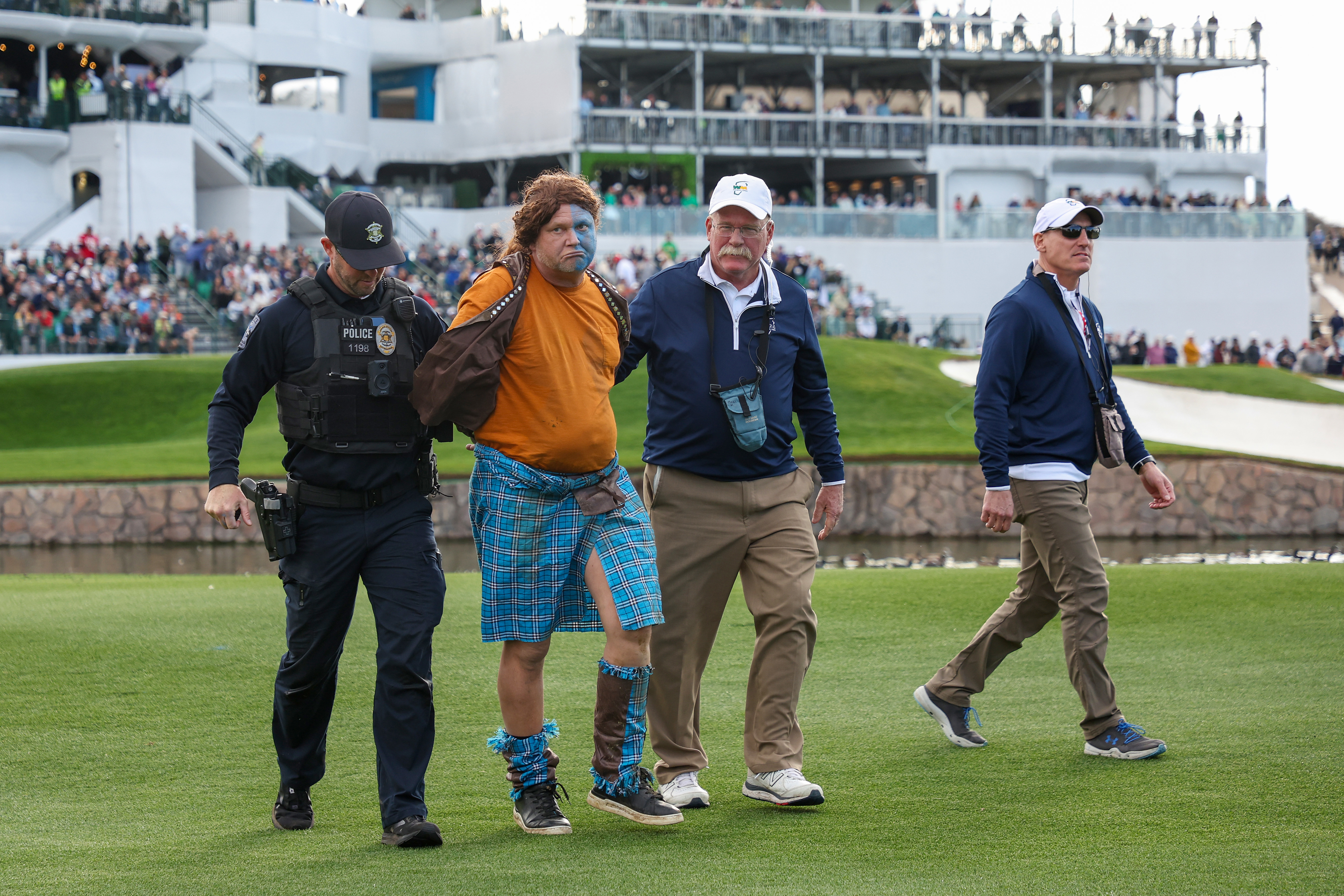 A fan dressed in costume as William Wallace from Braveheart is apprehended at the WM Phoenix Open.