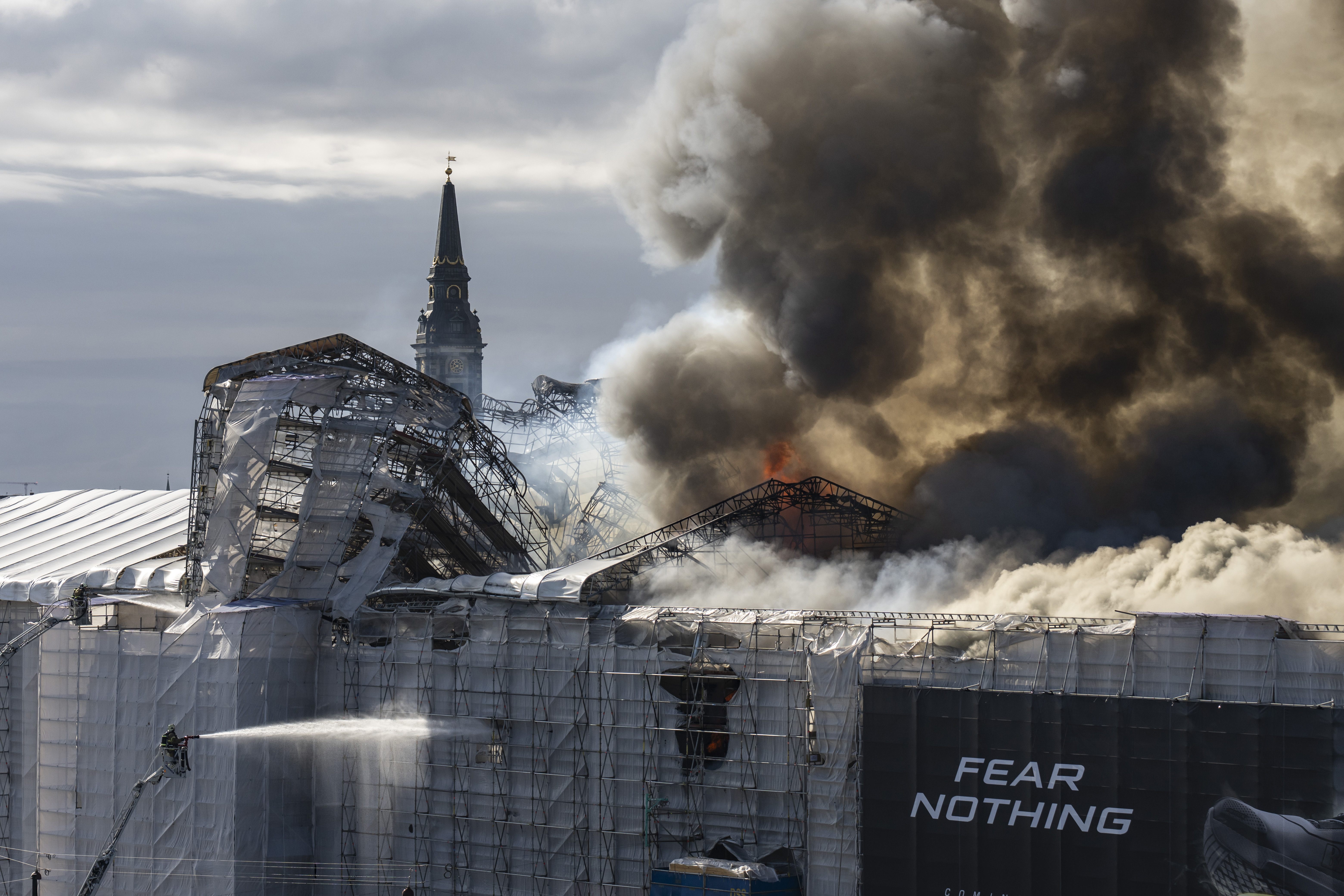 Firefighters work as smoke rises out of the Old Stock Exchange in Copenhagen, Denmark, Tuesday, April 16, 2024. 