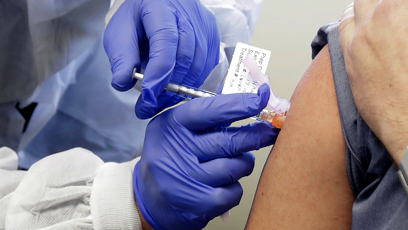 Neal Browning receives a shot in the first-stage safety study clinical trial of a potential vaccine for the COVID-19 coronavirus, Monday, March 16, 2020, at the Kaiser Permanente Washington Health Research Institute in Seattle.  (AP Photo/Ted S. Warren)