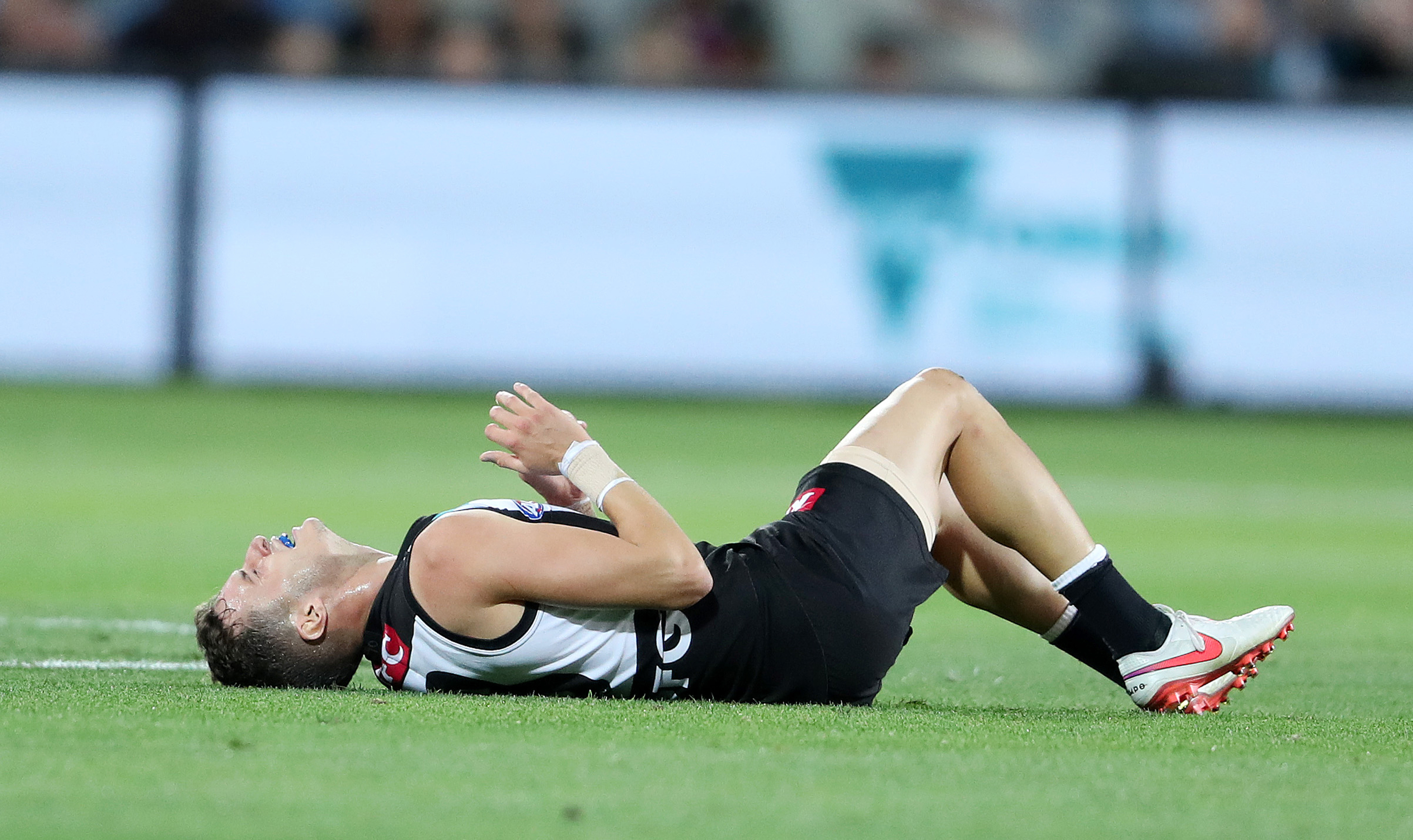 ADELAIDE, AUSTRALIA - APRIL 09: Orazio Fantasia of the Power down with an ankle injury during the 2021 AFL Round 04 match between the Port Adelaide Power and the Richmond Tigers at Adelaide Oval on April 09, 2021 in Adelaide, Australia. (Photo by Sarah Reed/AFL Photos)