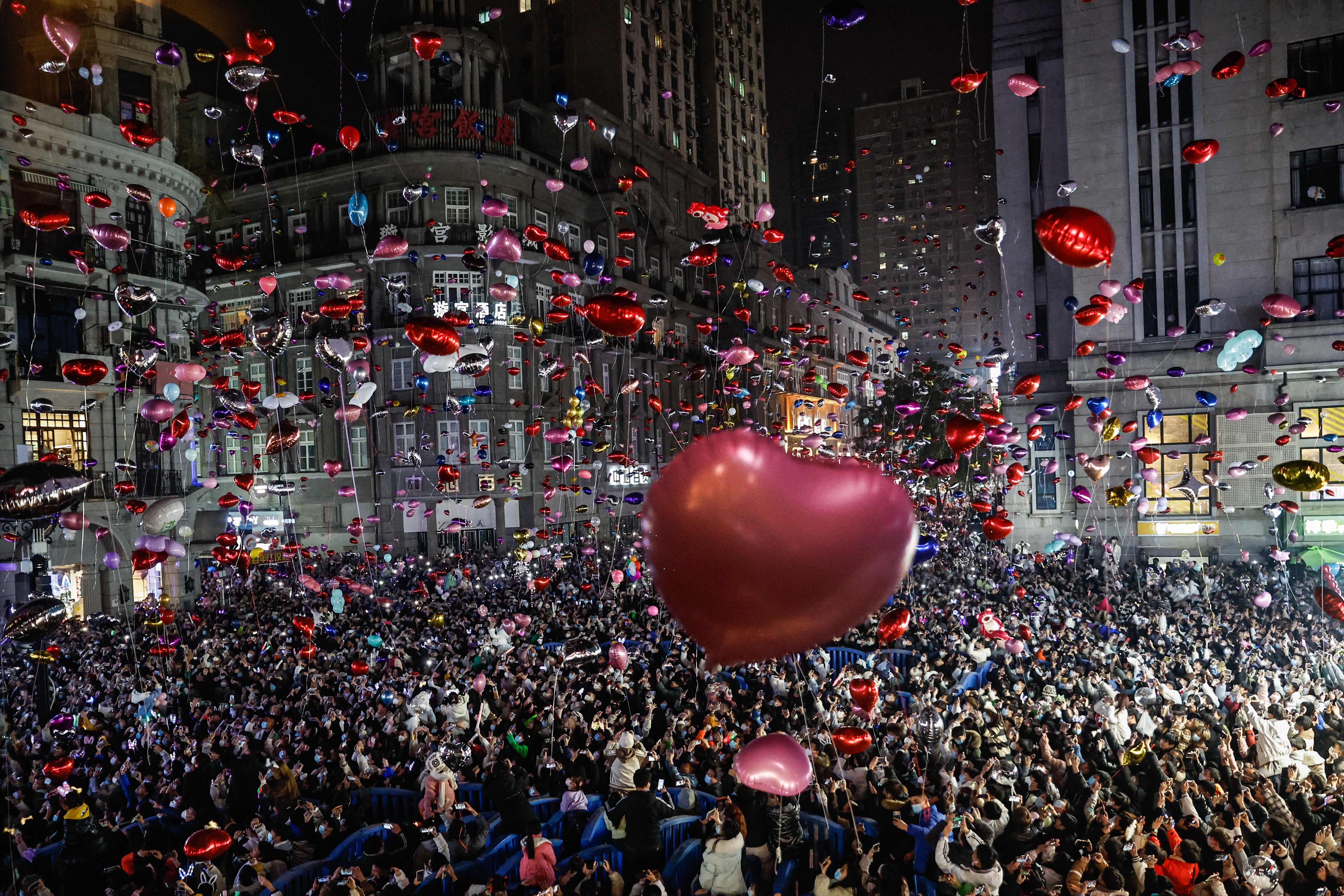 Revellers release balloons to celebrate the New Year on pedestrian street Jianghan Road on December 31, 2022 in Wuhan, China.