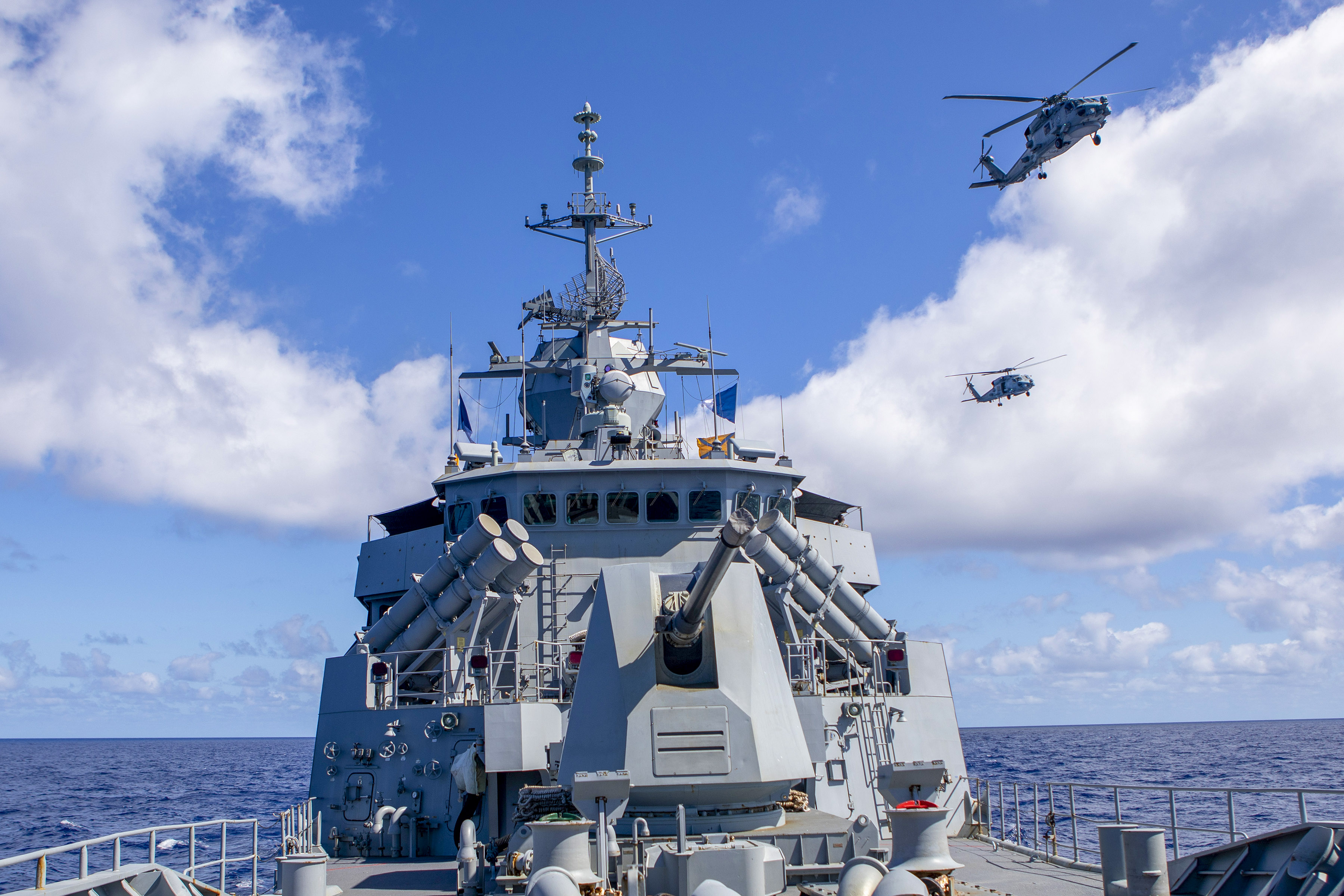 HMAS Ballarats embarked MH-60R helicopter flies in formation with a United State Navy MH-60R, off the coast of Queensland, during Exercise Talisman Sabre 2021.