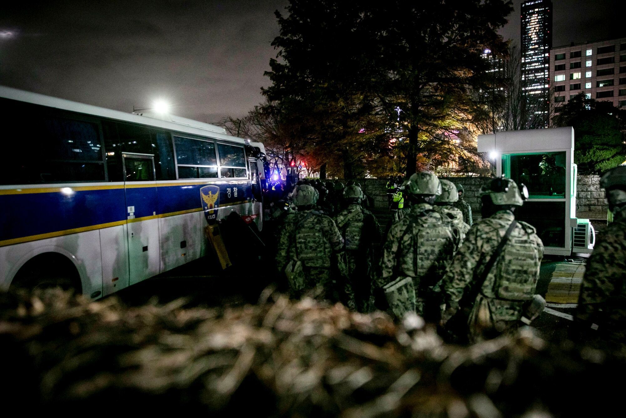 Soldiers wait to board a bus while leaving the National Assembly after lawmakers voted to demand the lifting of martial law earlier declared by South Korean President Yoon Suk Yeol in Seoul, South Korea, early on Wednesday, Dec. 4, 2024. Yoon stunned voters, lawmakers and investors by declaring martial law on Tuesday after accusing the opposition of trying to paralyze his administration amid a political rift that is set to deepen markedly. Photographer: Woohae Cho/Bloomberg