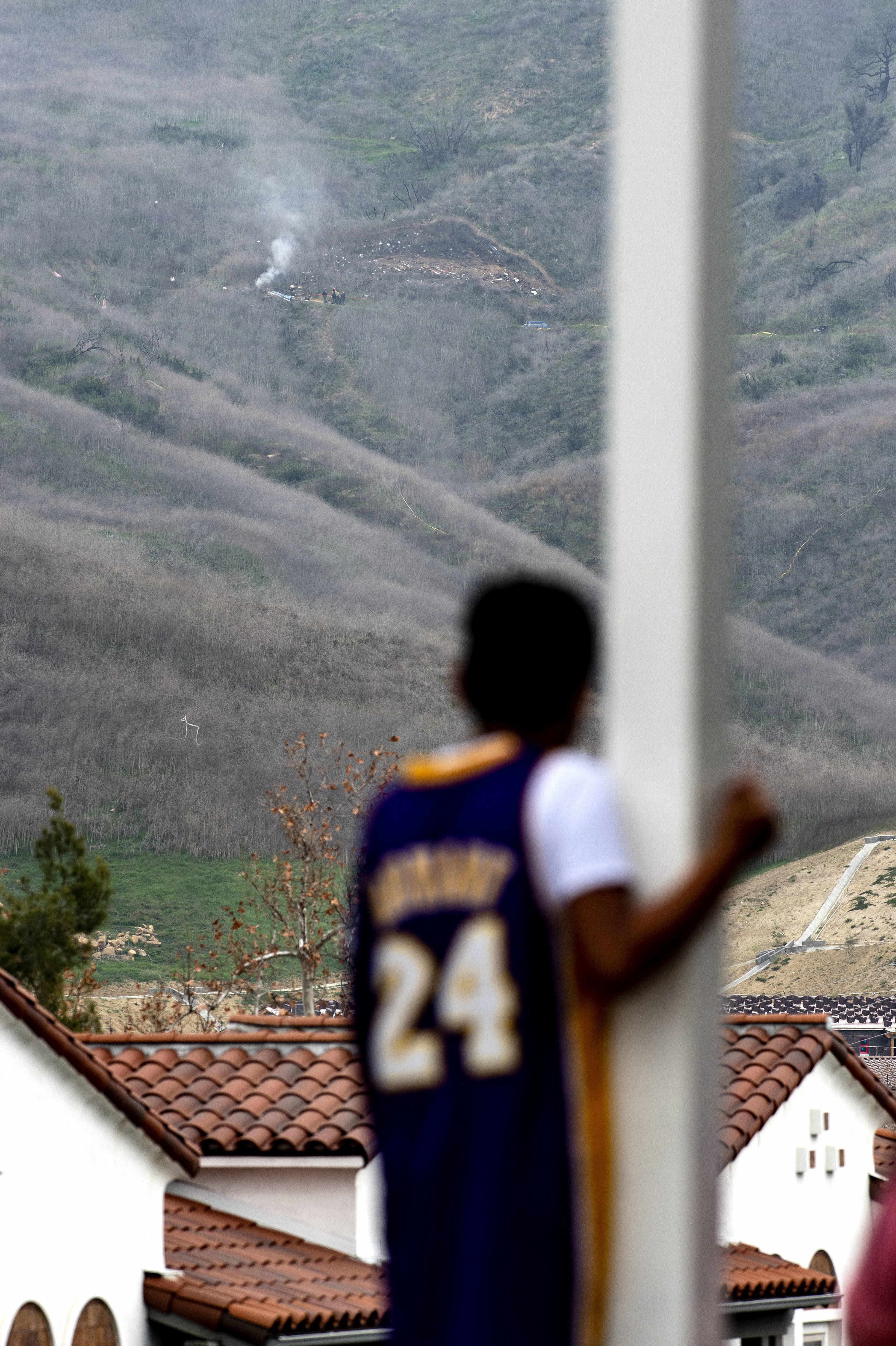 A young LA Lakers fan looks up to the hill where NBA legend Kobe Bryant was one of nine people killed in a helicopter crash.