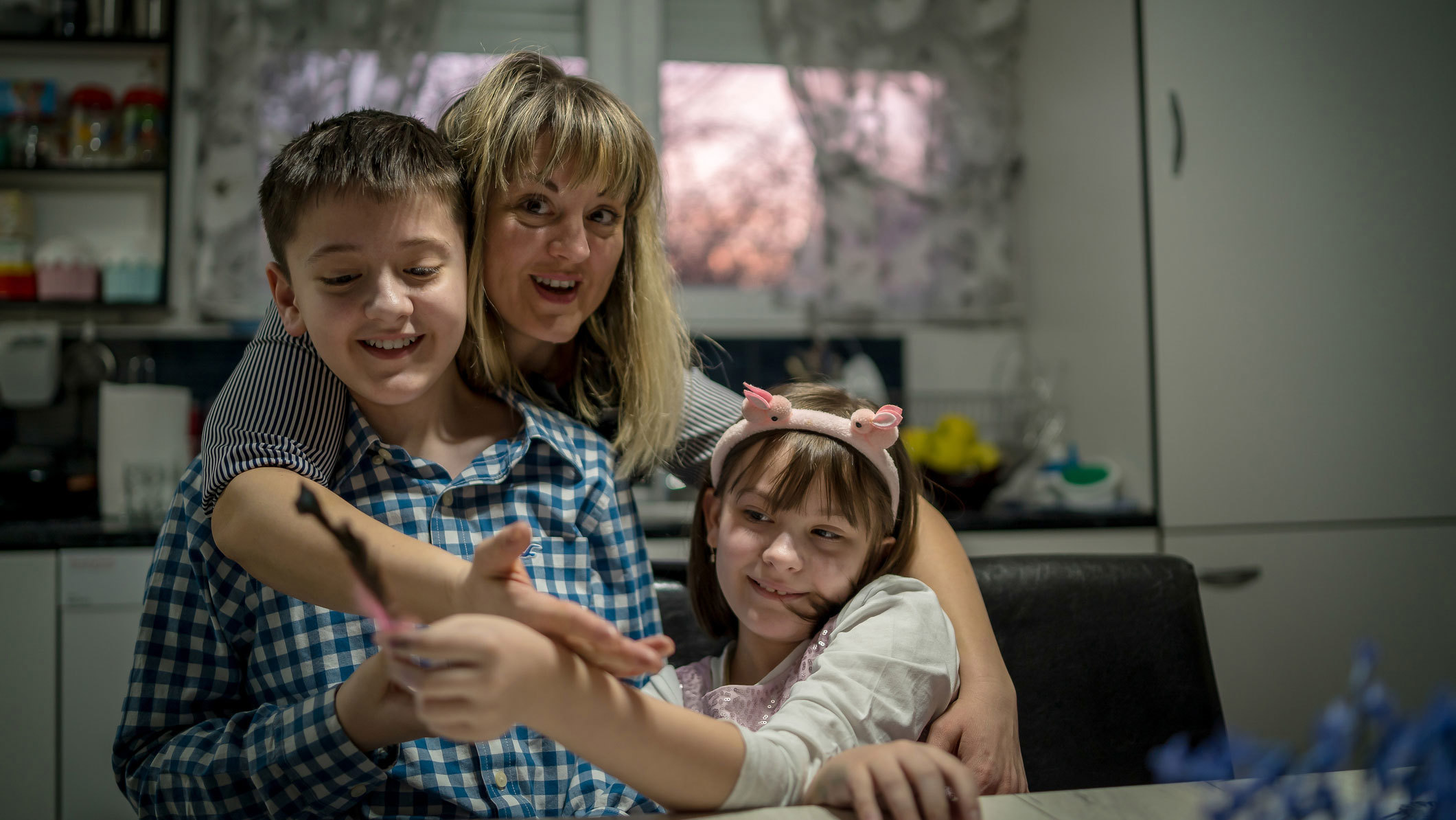 In this stock photo, a mother is pictured with her two children.