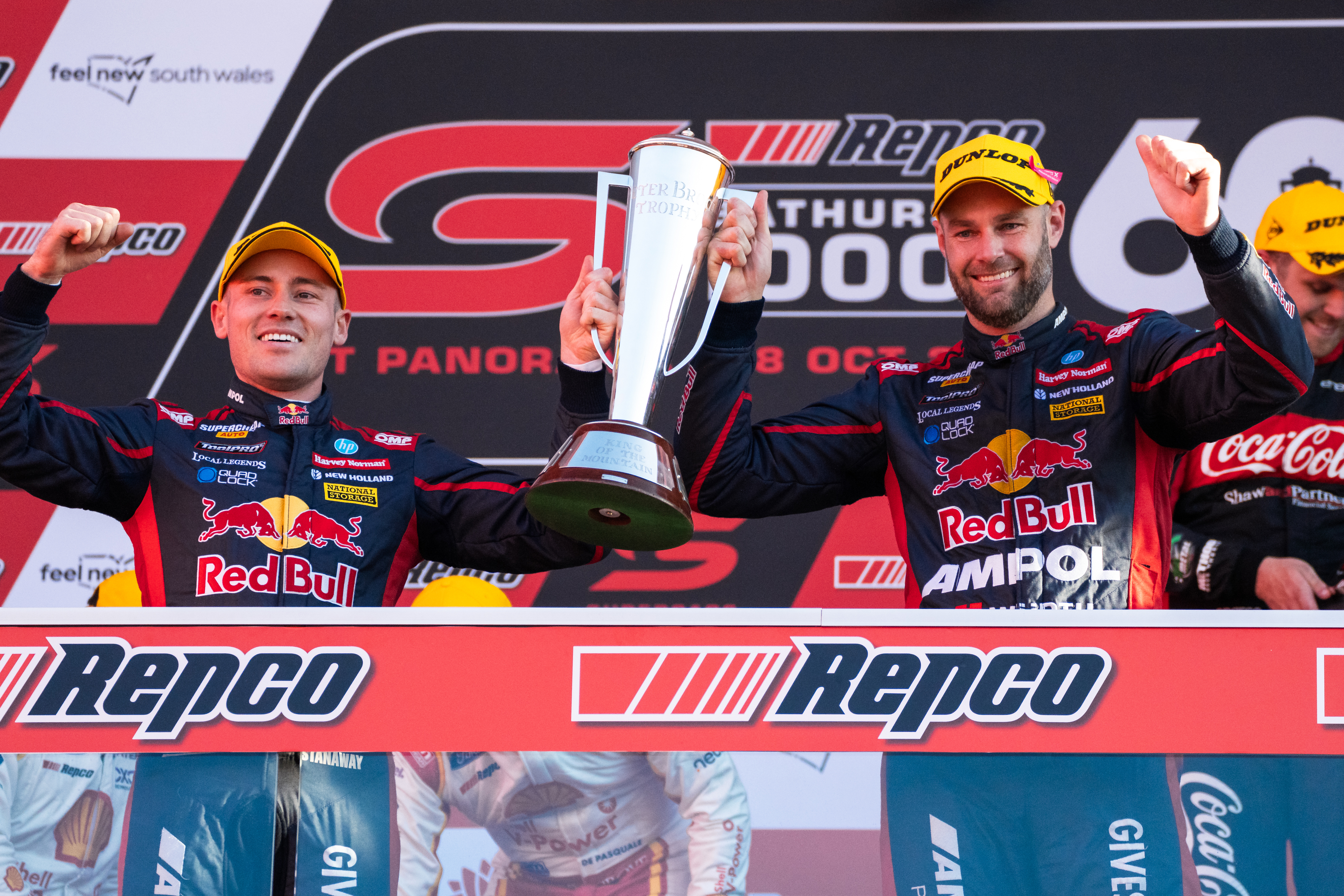Richie Stanaway (left) lofts the Peter Brock Trophy with Shane van Gisbergen.