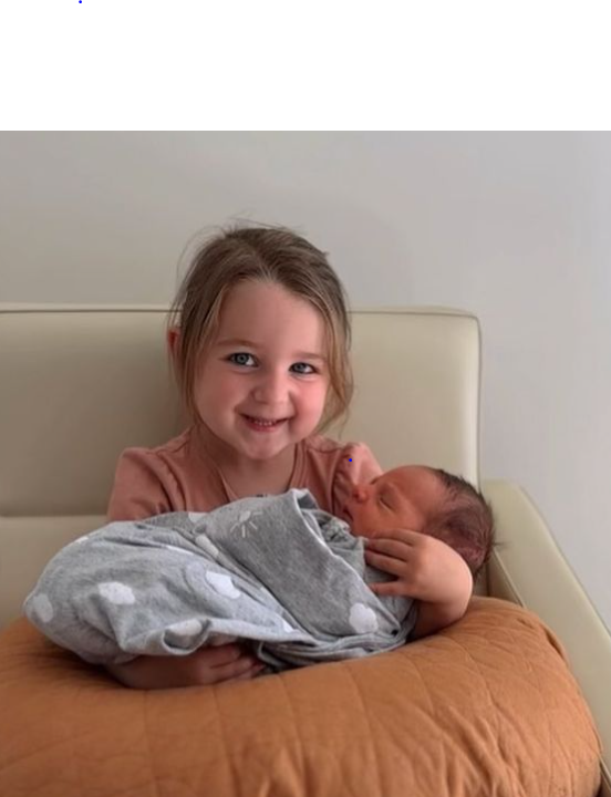 Kayla Itsines' daughter Arna cradles newborn Jax.