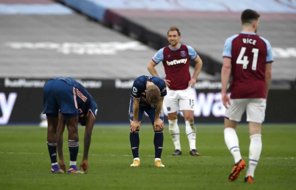 Arsenal's Martin Odegaard (centre) and Nicolas Pepe (left) crouch over tired after the Premier League match.