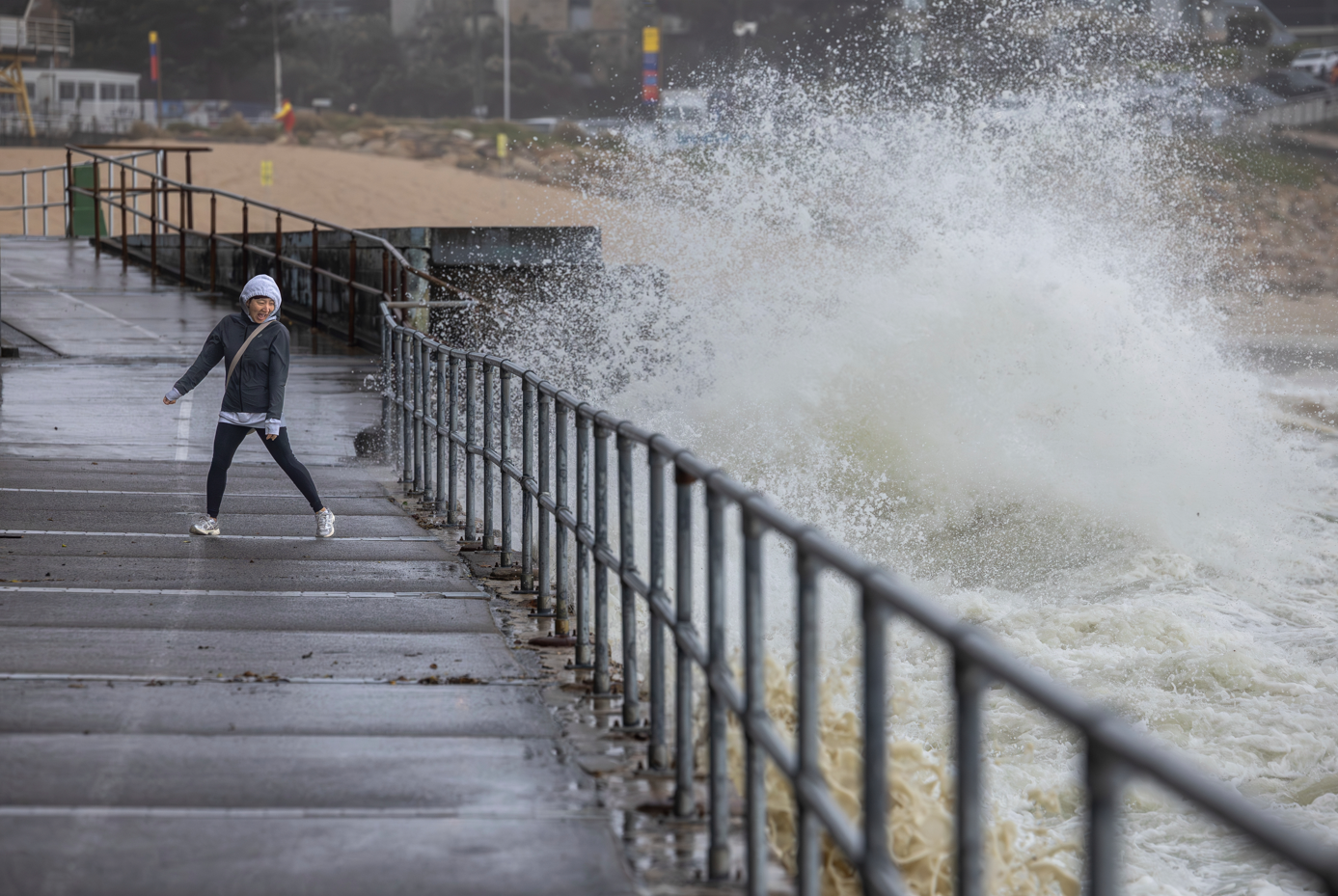 Wild seas surprise a person walking along the Cronulla esplanade on Saturday morning. 