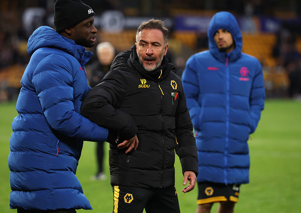 Vitor Pereira is held after clashing with supporters after their defeat.