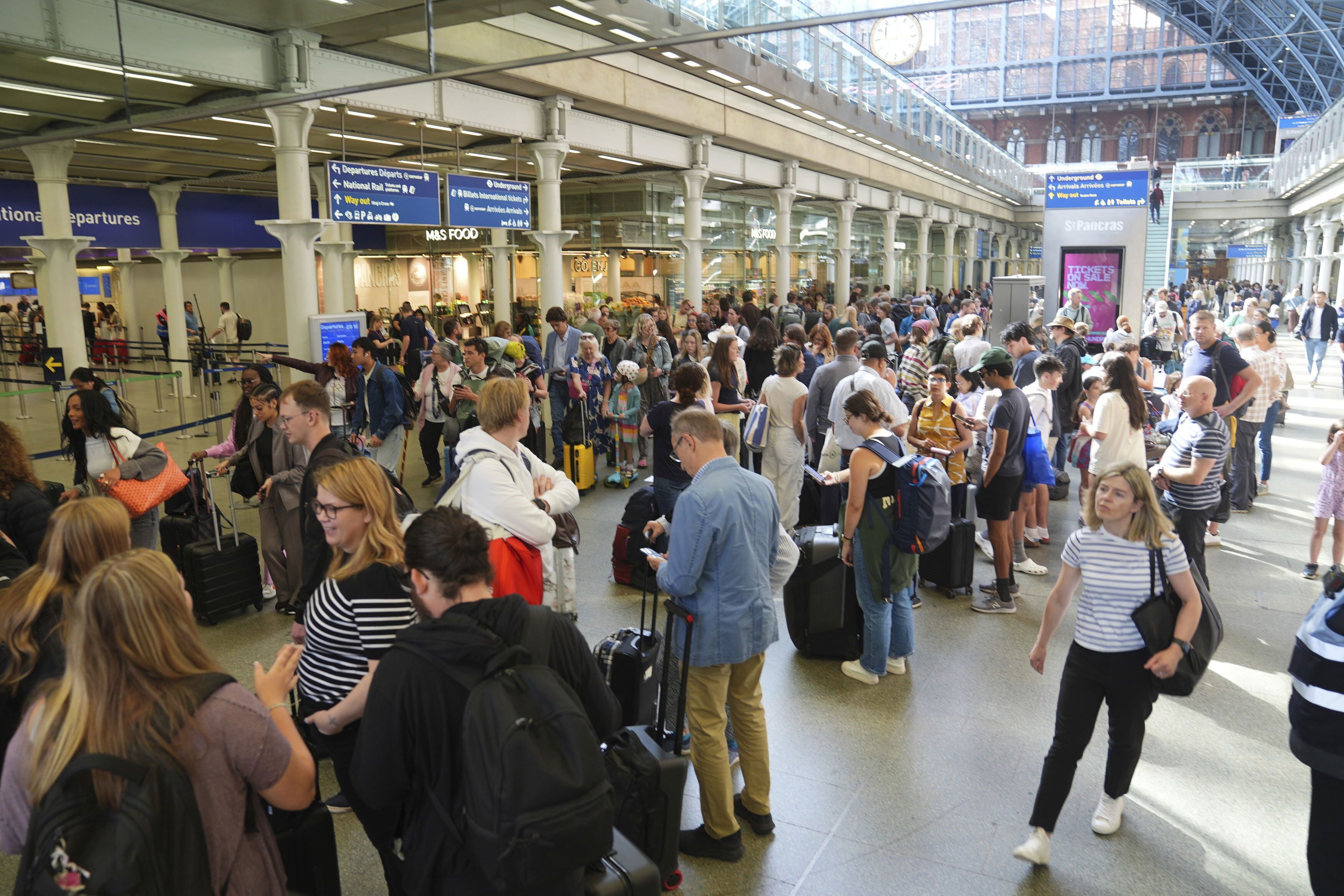 Passengers queue at the Eurostar terminal at St. Pancras station in central London, Friday July 26, 2024. 