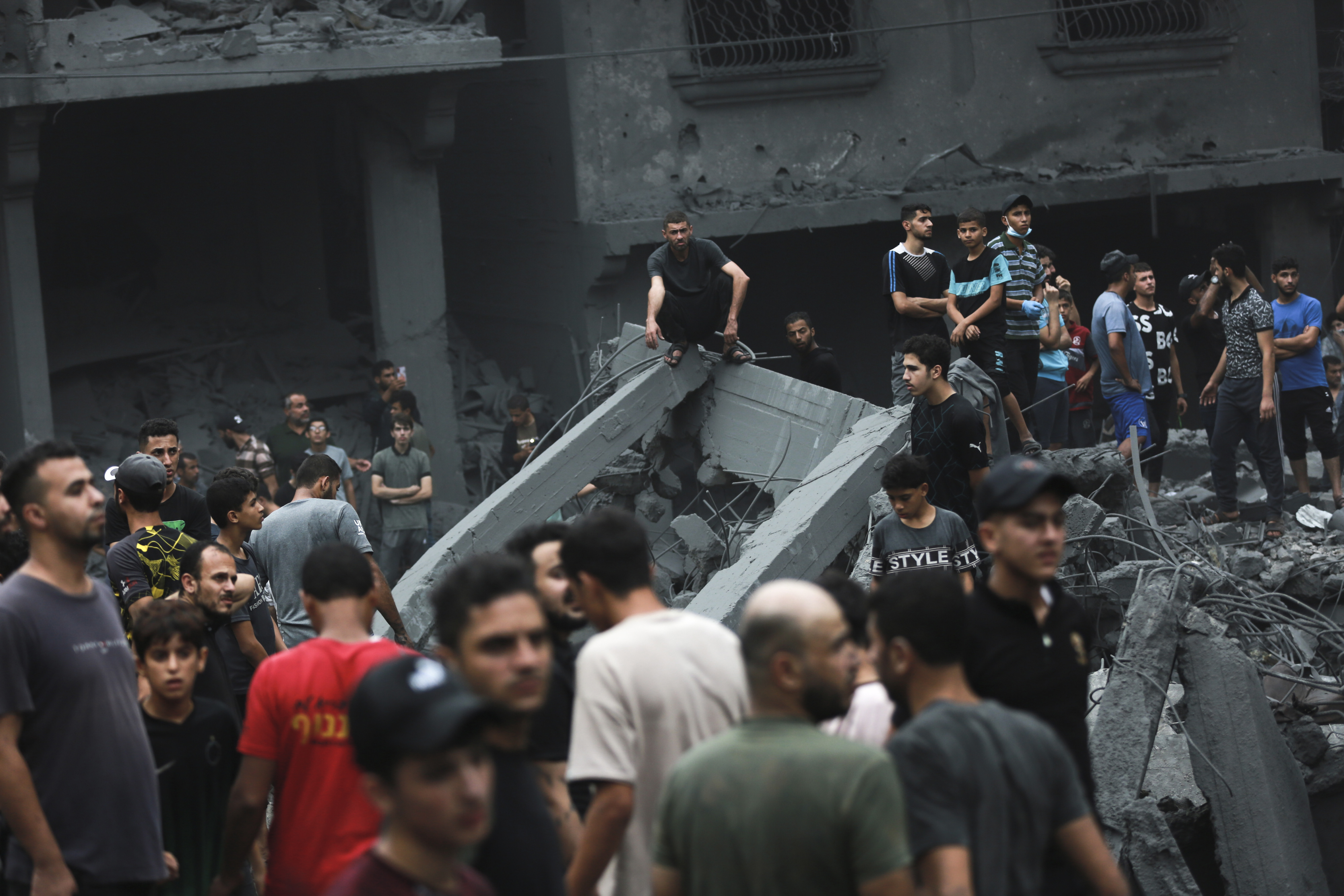 Palestinians inspect the damage of destroyed buildings following Israeli airstrikes on Gaza City, Friday, Oct. 27, 2023.