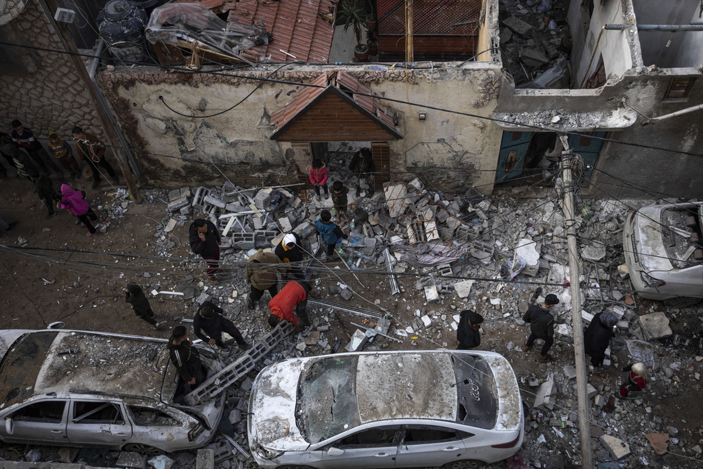 Palestinians look at the destruction after an Israeli airstrike in Rafah, Gaza Strip, Friday, Feb. 9, 2024