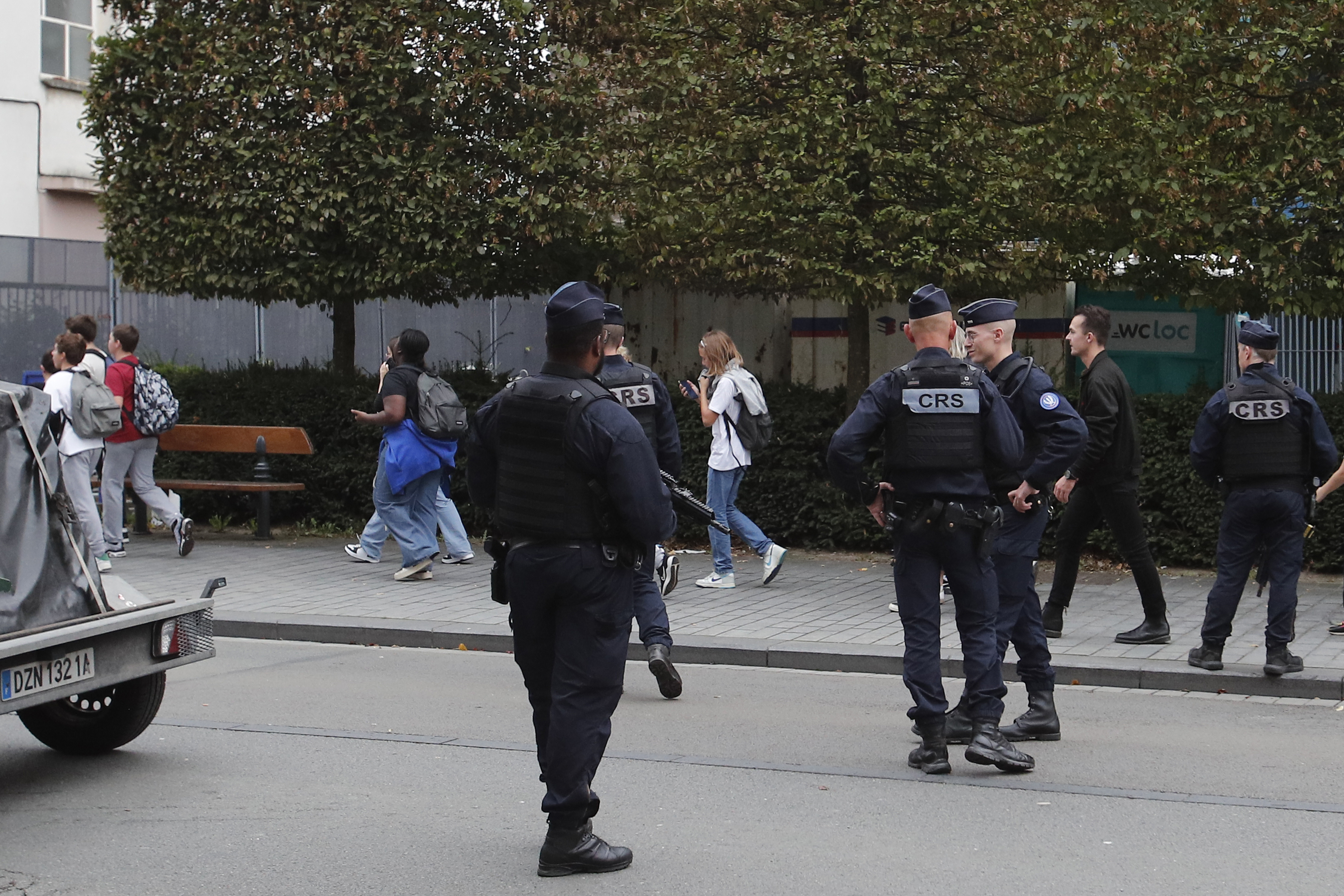 Schoolchildren leave the area after a man armed with a knife killed a teacher and wounded two others at a high school in northern France, Friday, Oct. 13, 2023 in Arras.