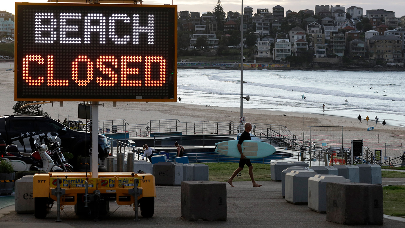 This April photo shows a sign at Bondi Beach as a surfer arrives at the Sydney beach.