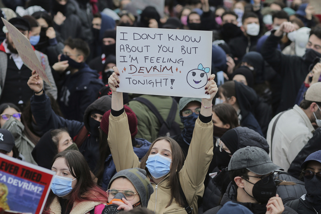 University students shout slogans during a protest at Besiktas district in Istanbul, Turkey, Monday, March 24, 2025, after Istanbul's Mayor Ekrem Imamoglu was arrested and sent to prison. The poster reads in English and Turkish: "I don't know about you but I'm feeling 'revolution' tonight!".