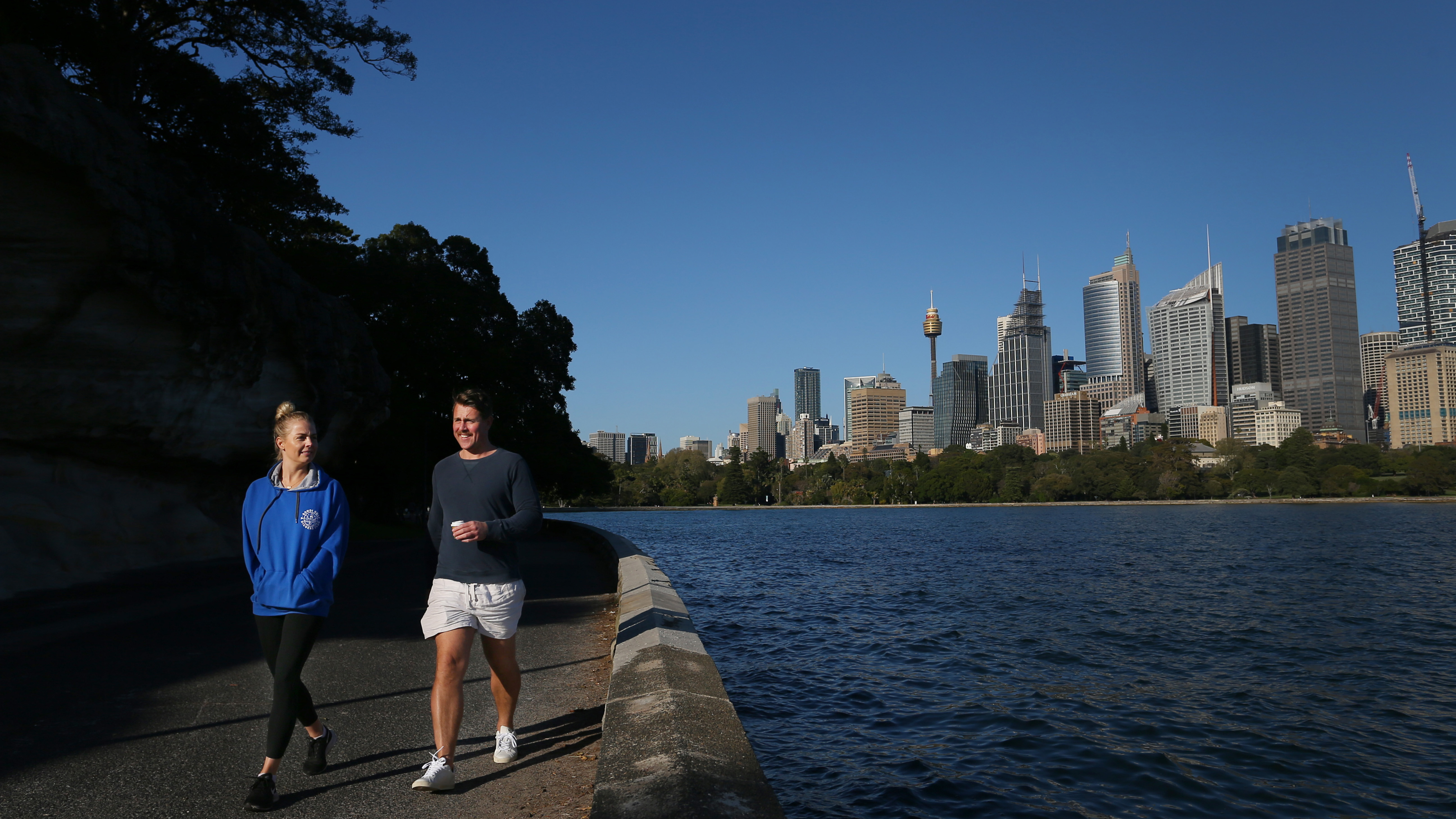 People are seen exercising along the Sydney Harbour shorefront 
