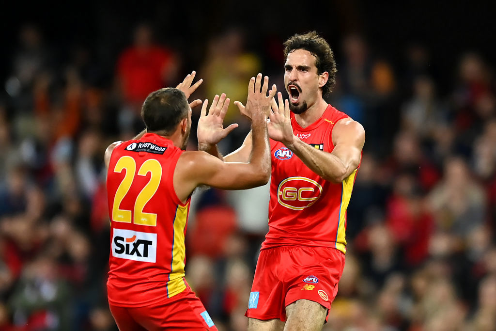 Ben King of the Suns celebrates kicking a goal.