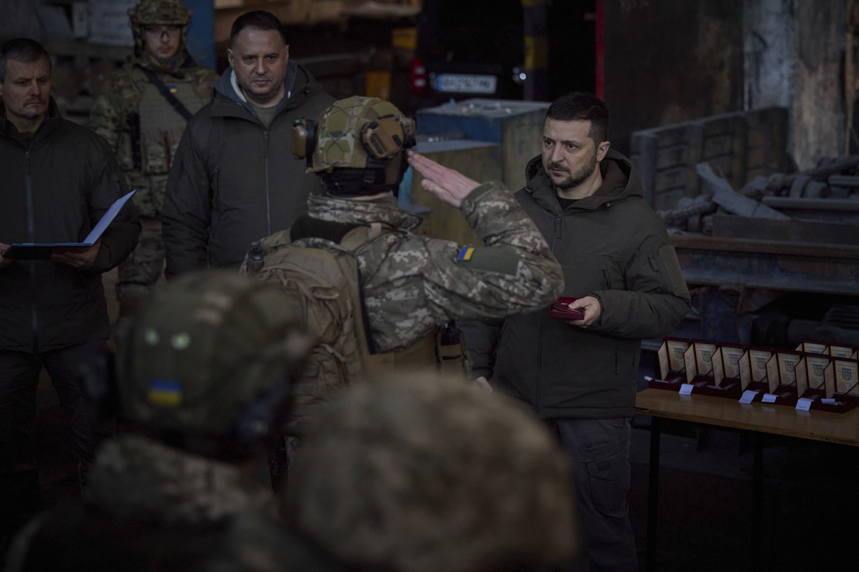 El presidente de Ucrania, Volodymyr Zelenskyy, a la derecha, premia a un militar en el lugar de las batallas más duras contra los invasores rusos en Bajmut, Ucrania, el martes 20 de diciembre de 2022. 