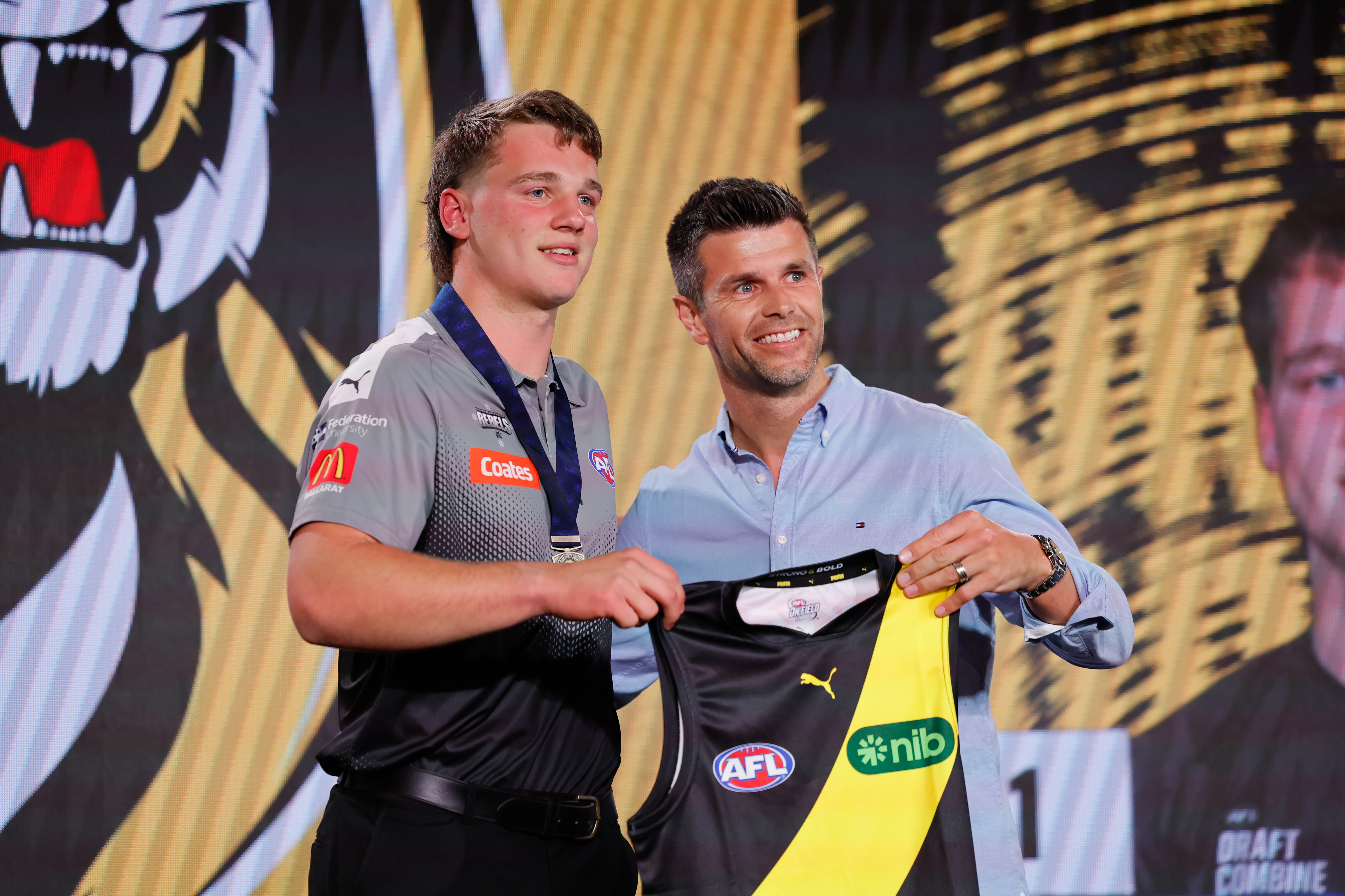 The number one pick, Sam Lalor is presented his Richmond jumper by Trent Cotchin.