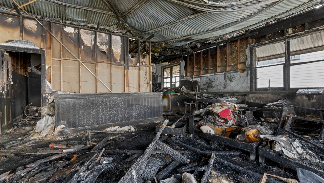 Buyers haggle over Brisbane's half-burnt house as it gets passed in at auction. Negotiations are underway to close the deal.