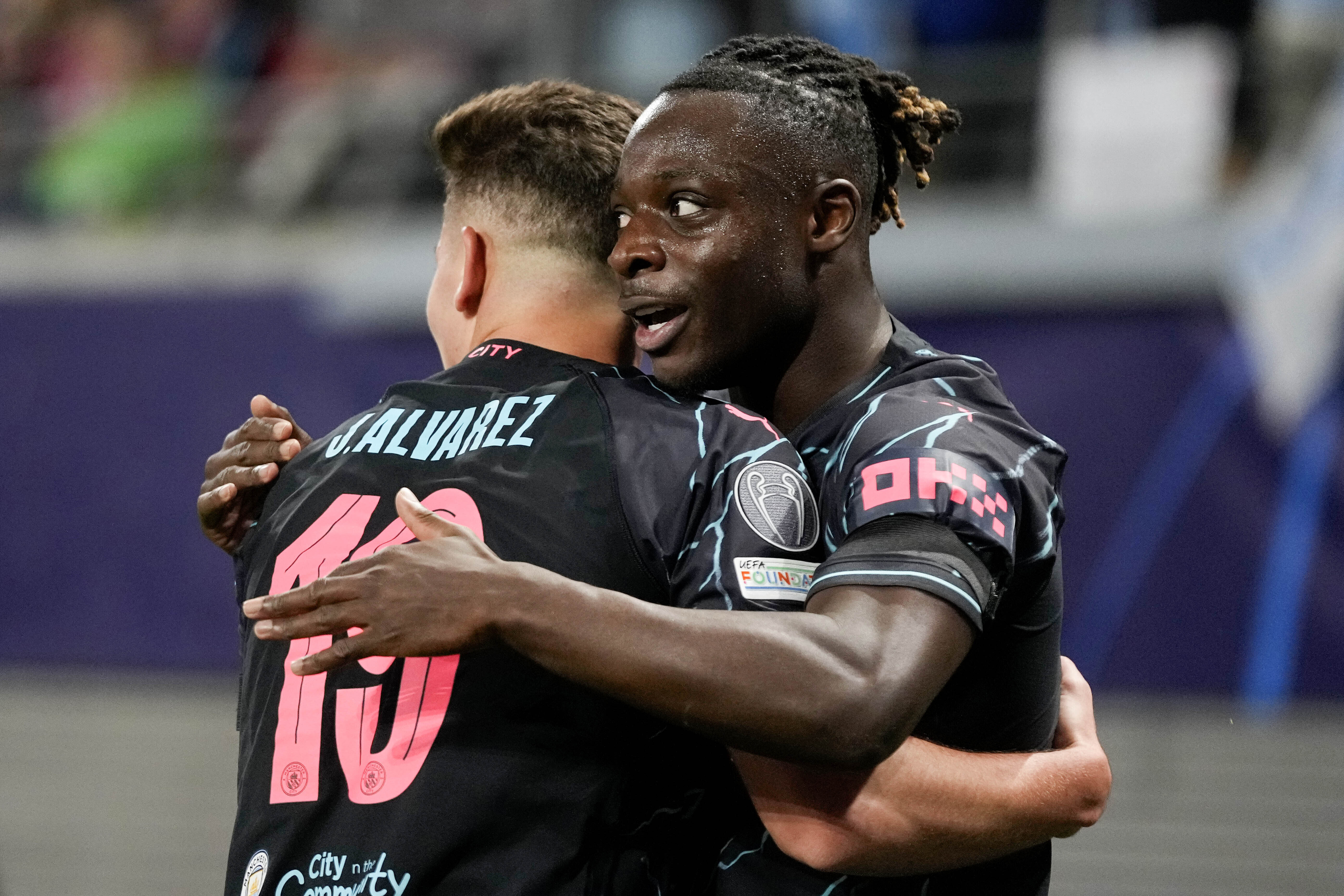 Manchester City's Jeremy Doku celebrates with his teammate Julian Alvarez.