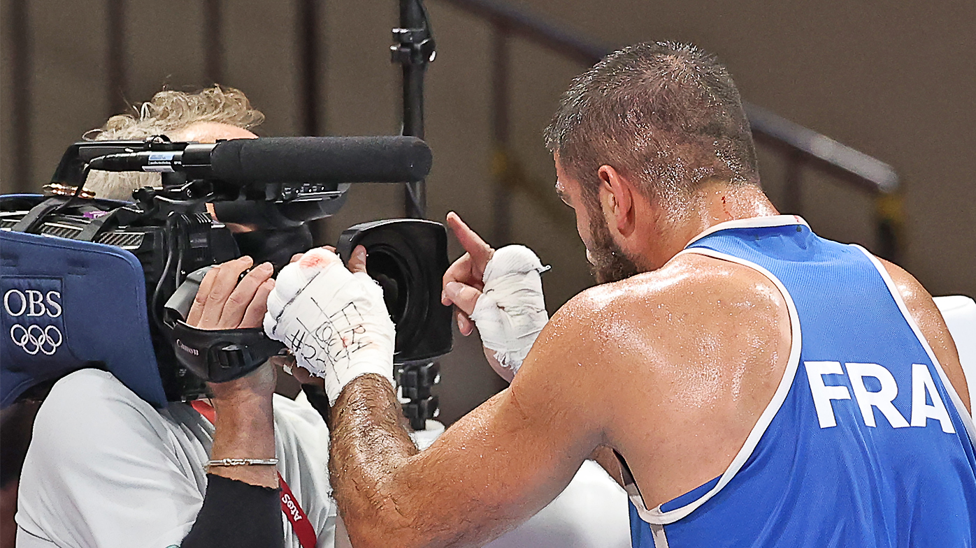  France's Mourad Aliev (R) stands in front of a cameraman after being disqualified for headbutting