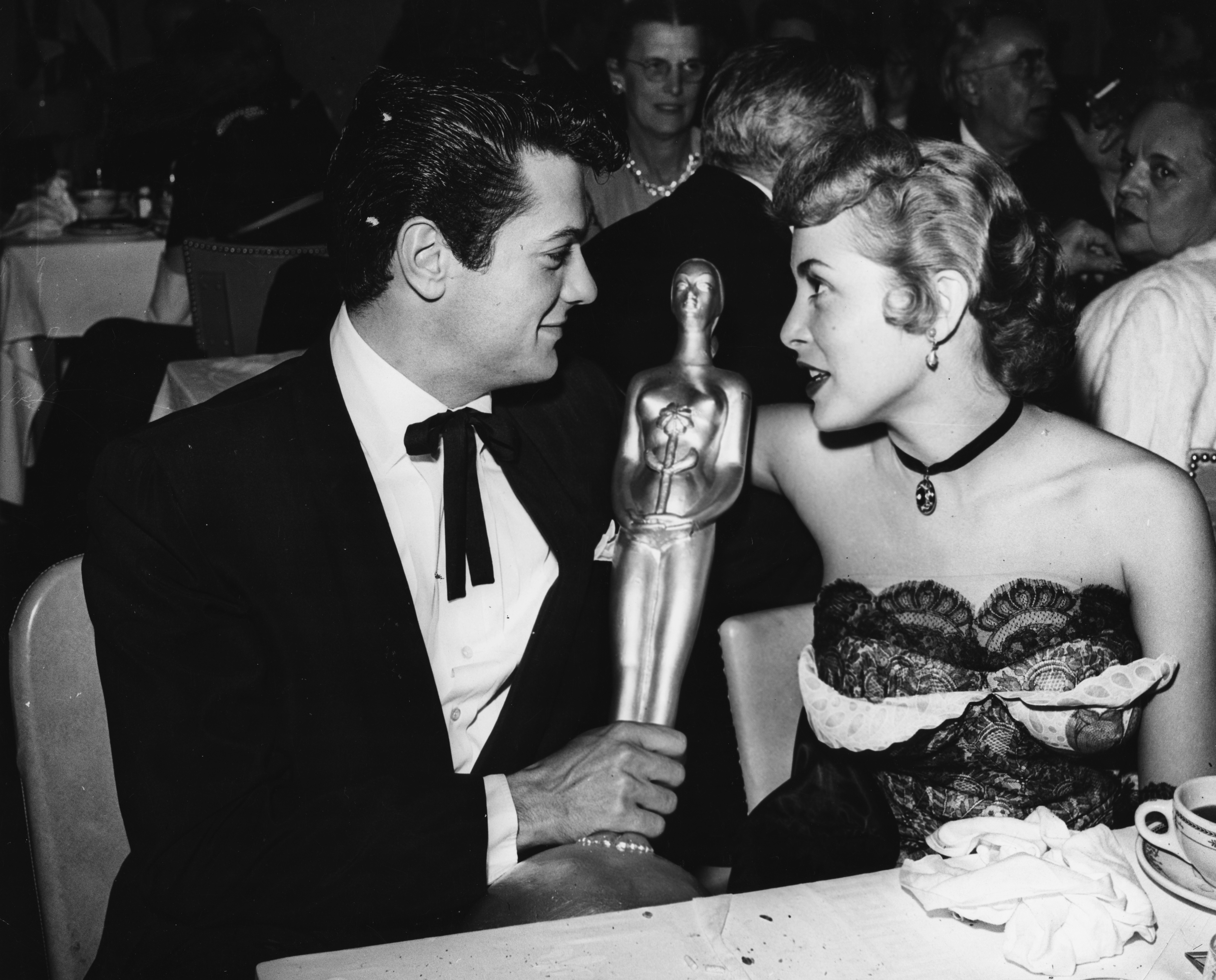 Tony Curtis showing his 'Henrietta' award to wife Janet Leigh at the Golden Globe Awards, Los Angeles, February 28, 1957. 
