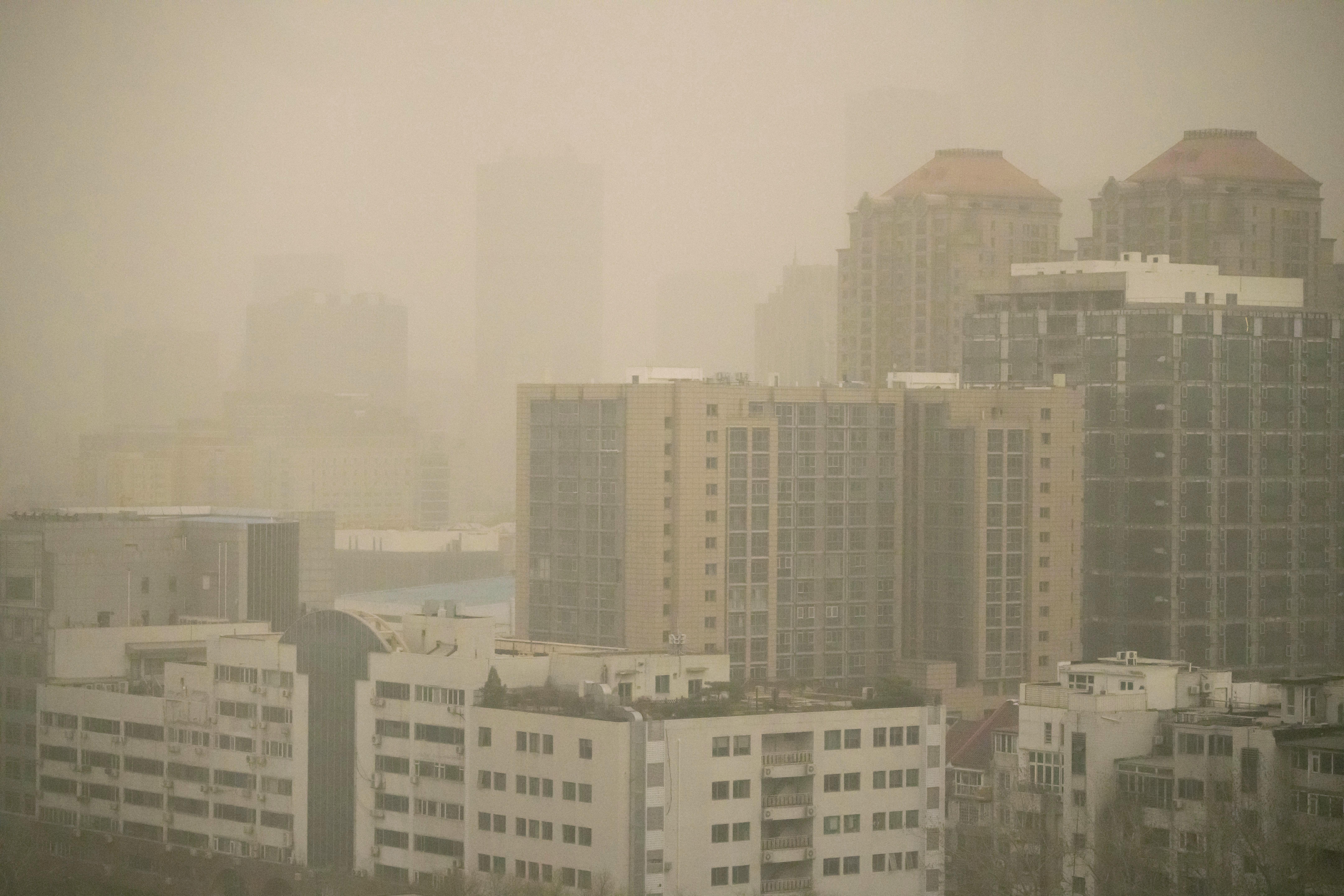 Haze and dust envelops buildings in Beijing, Friday, March 10, 2023. 