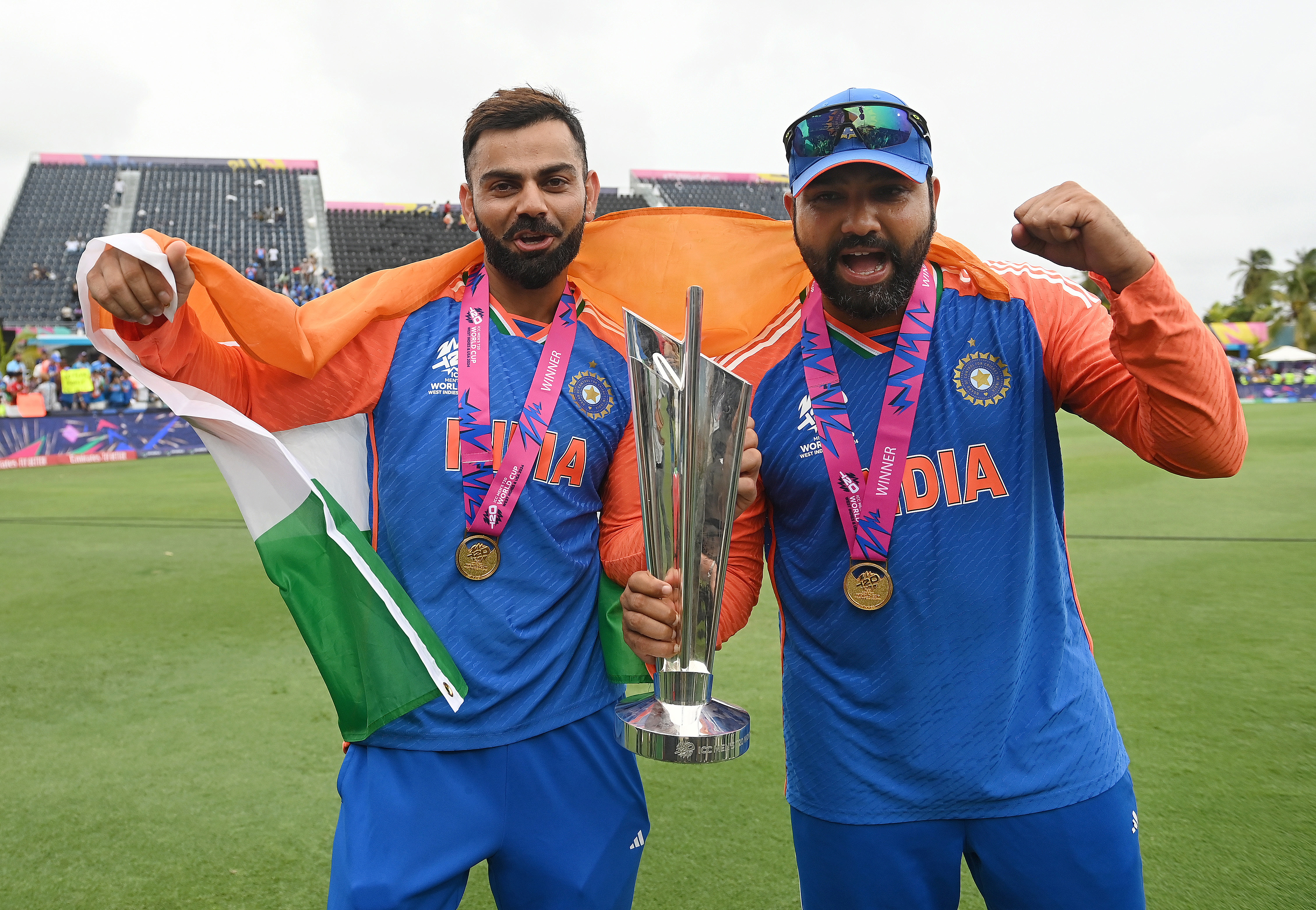 Virat Kohli (L) and Rohit Sharma hold the trophy after India won the ICC Men's T20 Cricket World Cup West Indies & USA 2024 Final match between South Africa and India at Kensington Oval on June 29, 2024 in Bridgetown, Barbados. (Photo by Philip Brown/Getty Images)