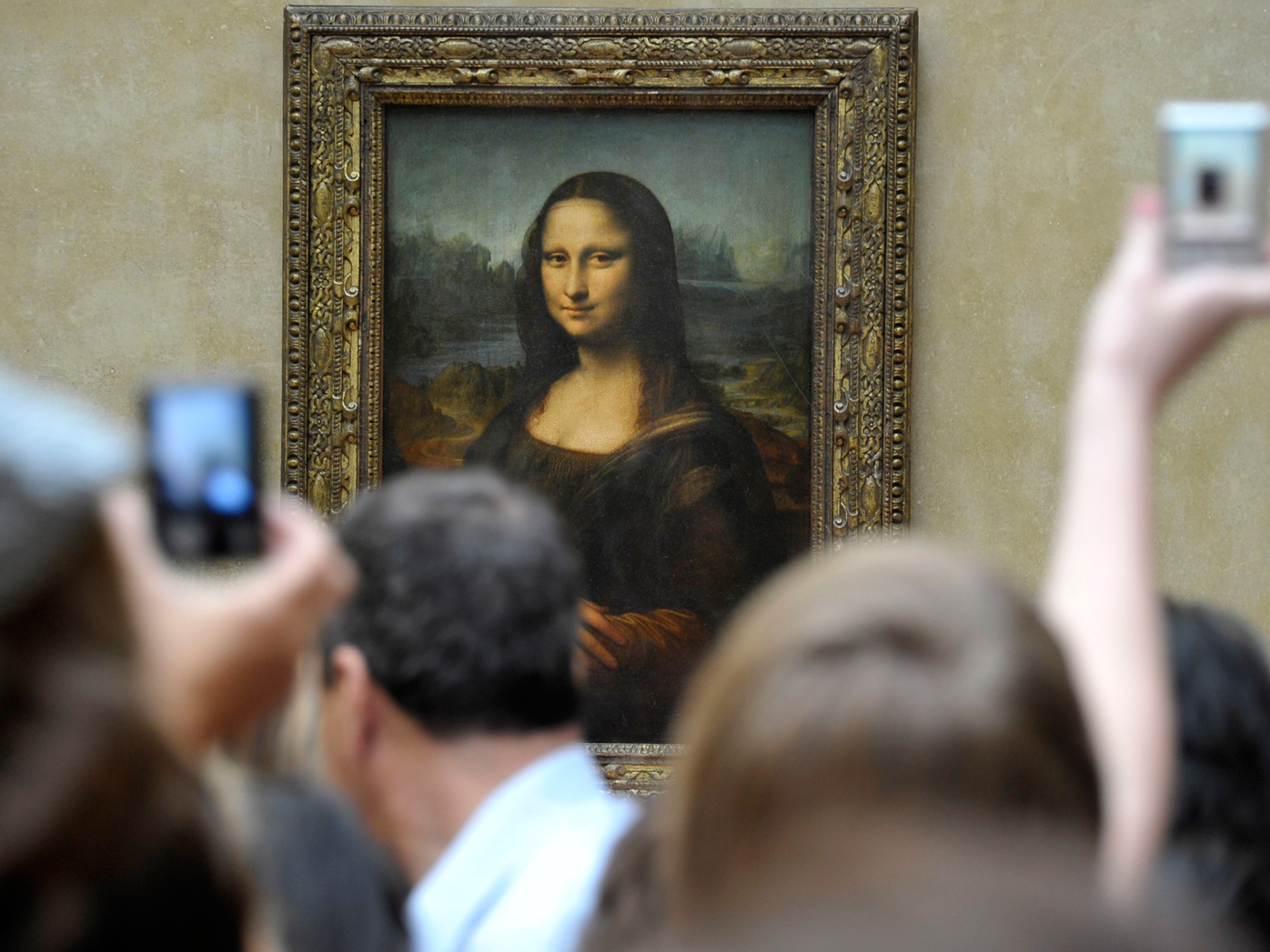 Visitors take pictures of Leonardo da Vinci's Mona Lisa, at the Louvre Museum in Paris