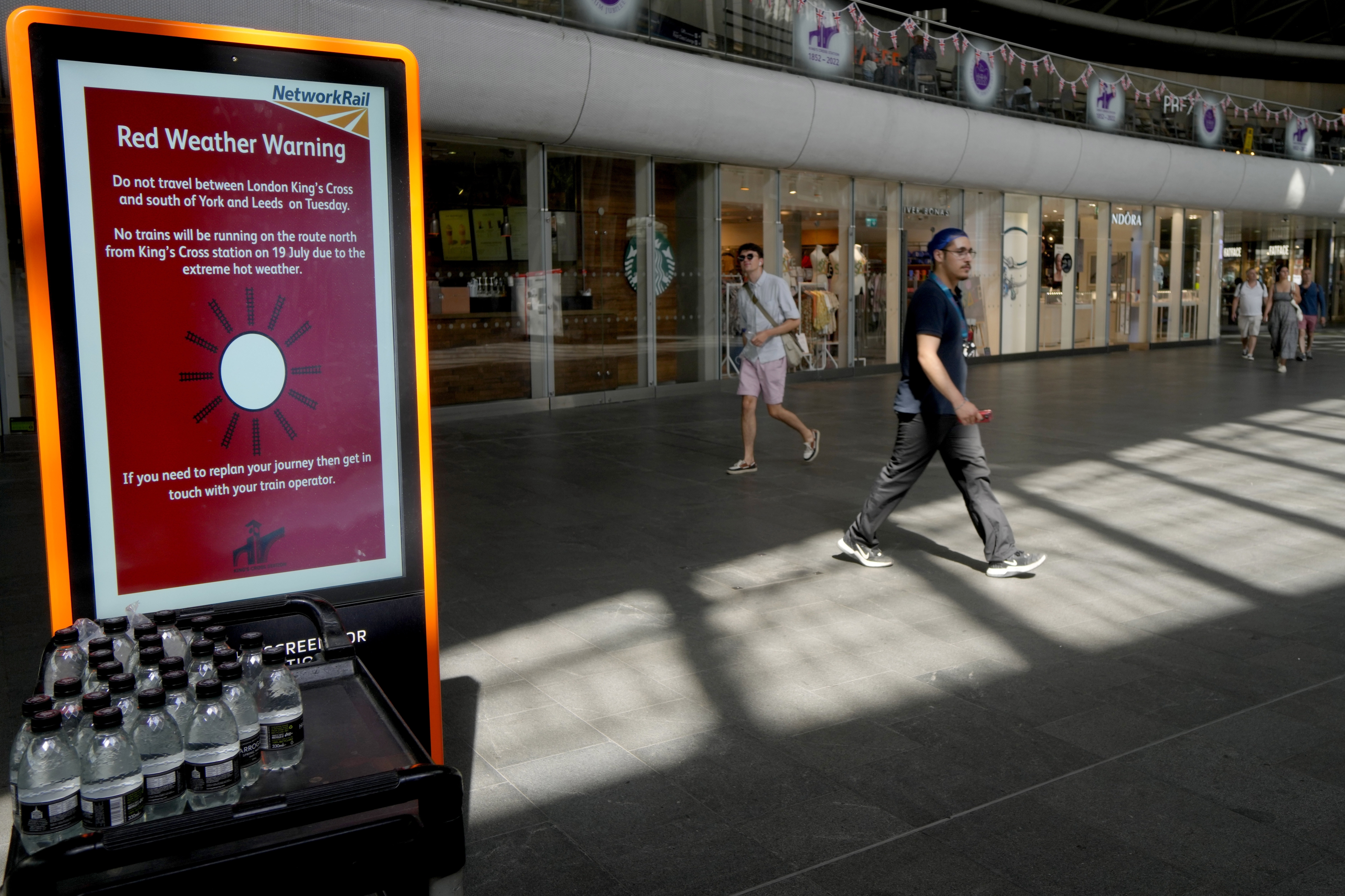 A sign at King's Cross railway station warns of train cancellations due to the heat in London, July 19, 2022. 