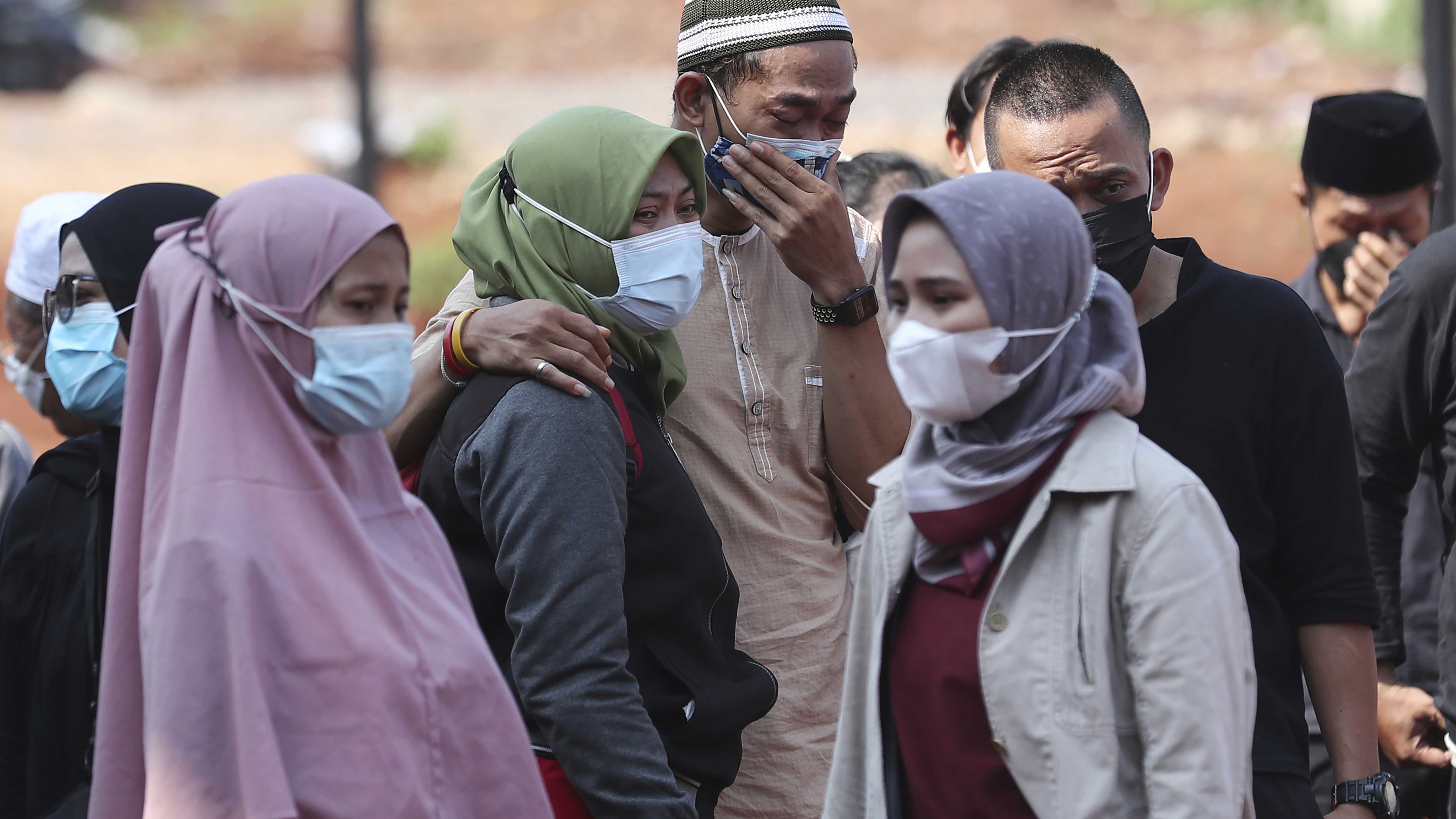 Family members mourn during a burial at the special section of Jombang Public Cemetery reserved for those who died of COVID-19, in Tangerang, on the outskirts of Jakarta, Indonesia.