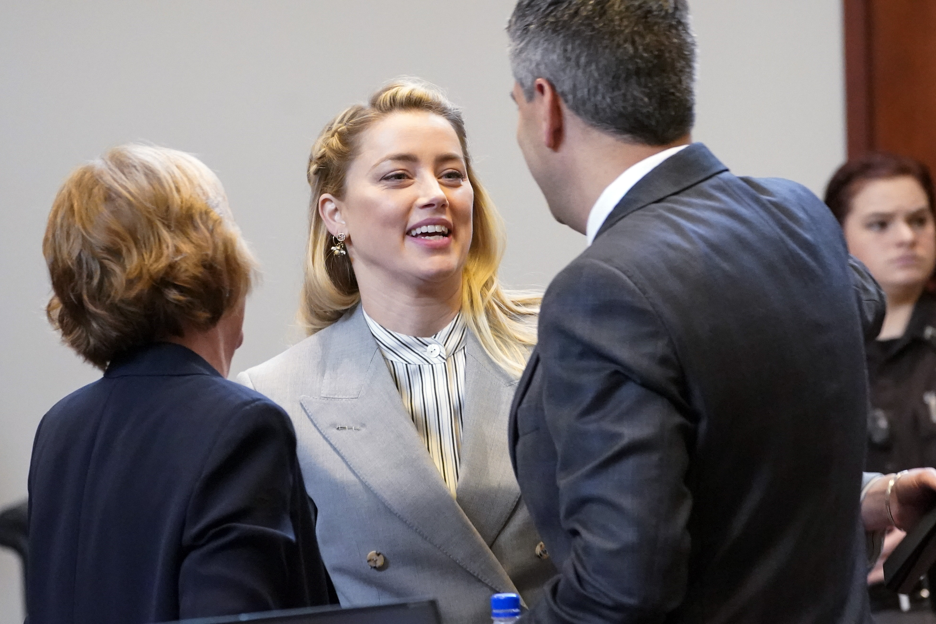 Amber Heard talks with her legal team including Elaine Bredehoft, left, and Benjamin Rottenborn,