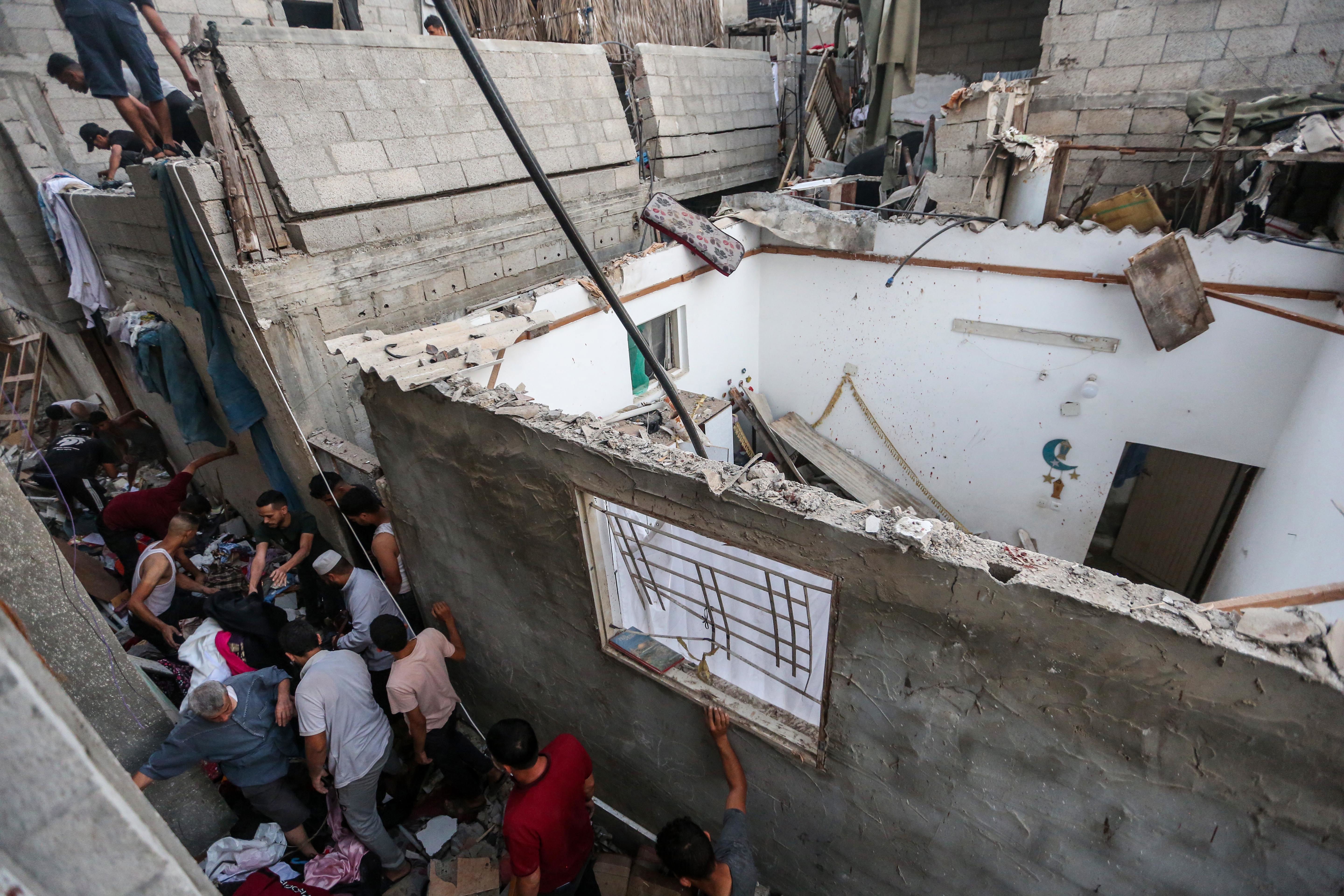 People search through buildings that were destroyed during Israeli air raids