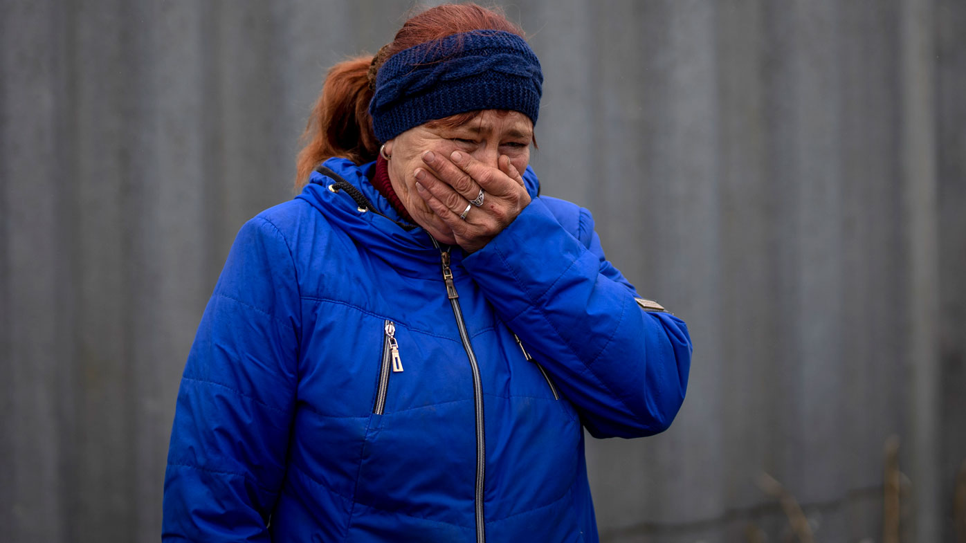 Ira Slepchenko, 54, cries looking at the coffins, one of them with the body of her husband Sasha Nedolezhko