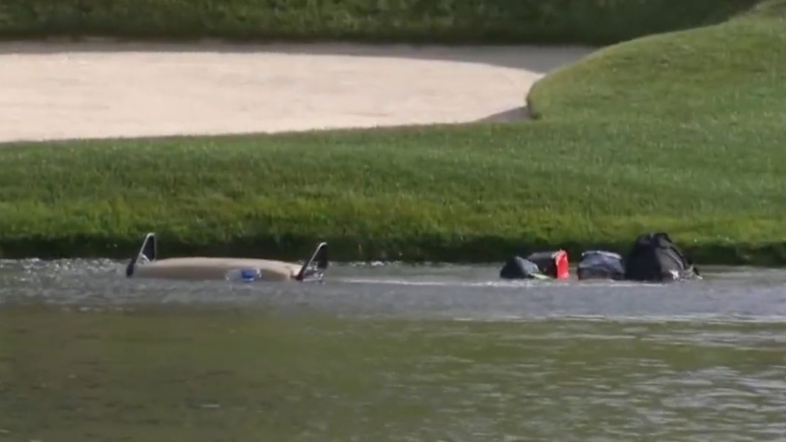 A runaway golf cart dips beneath the surface after it crashed into a pond during the first round of the Travelers Championship in the US.