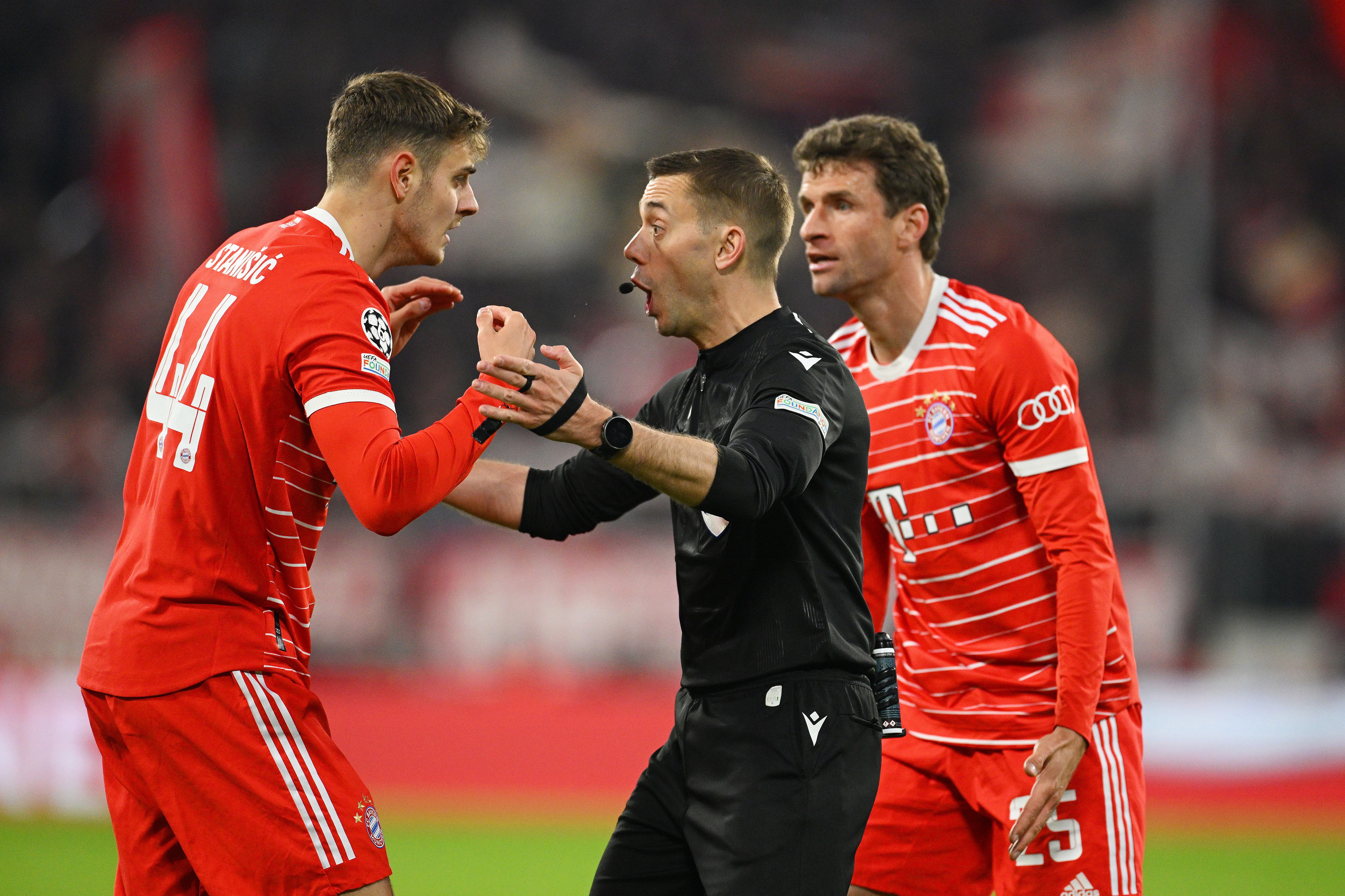Josip Stanisic and Thomas Muller of Bayern Munich react towards referee Clement Turpin.