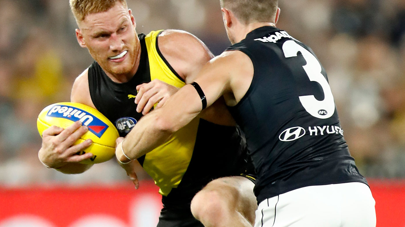Nick Vlastuin of the Tigers is tackled by Marc Murphy of the Blues during the round one AFL match between the Richmond Tigers and the Carlton Blues.