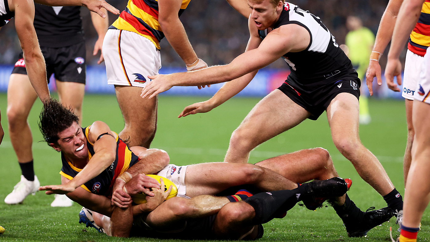 Scott Lycett of the Power tackles Ned McHenry of the Crows